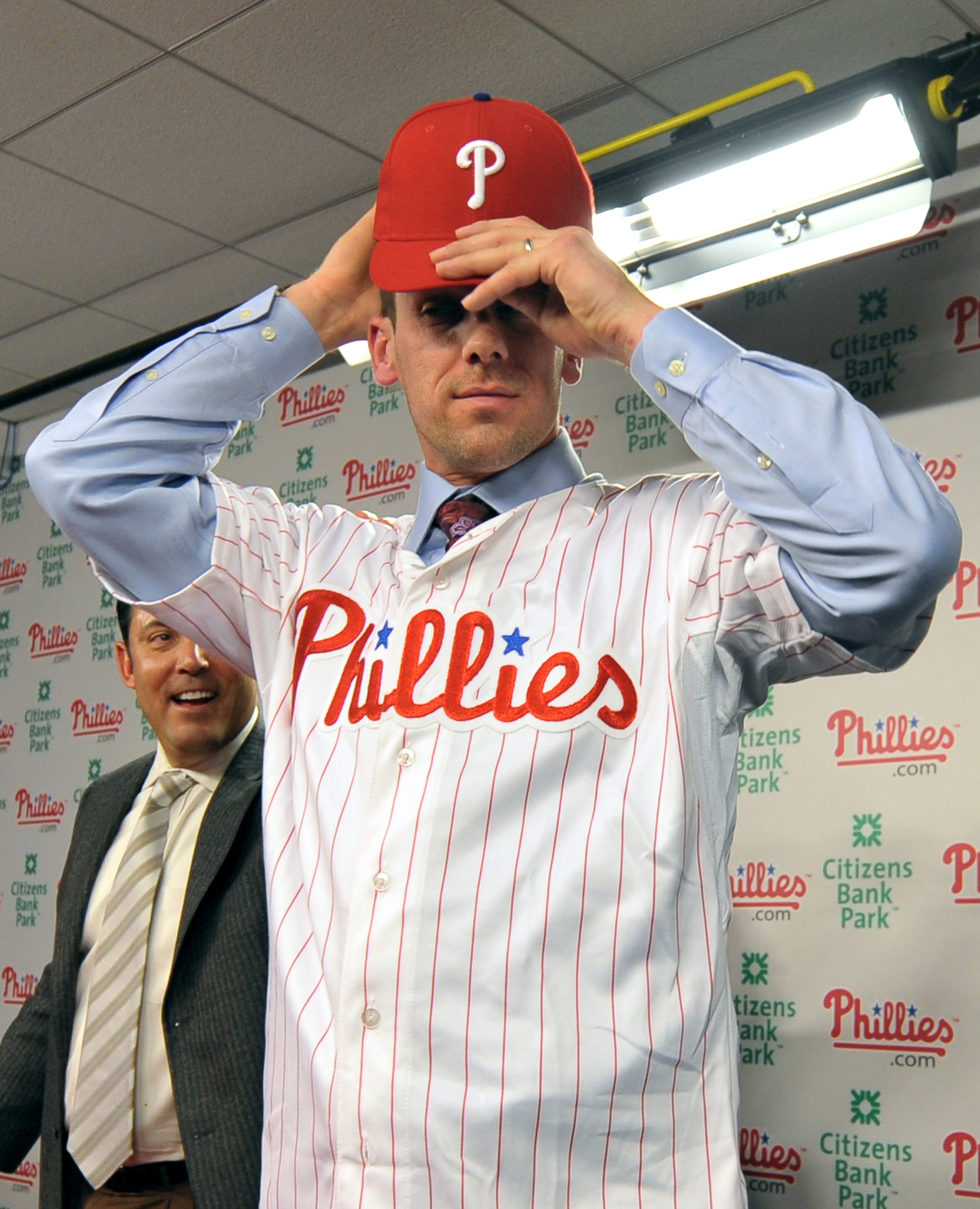 PHILADELPHIA - DECEMBER 15: Pitcher Cliff Lee #33 of the Philadelphia Phillies adjusts his hat after being introduced to the media during a press conference as Philadelphia Phillies general manager Ruben Amaro Jr. (L) looks on at Citizens Bank Park on Dec