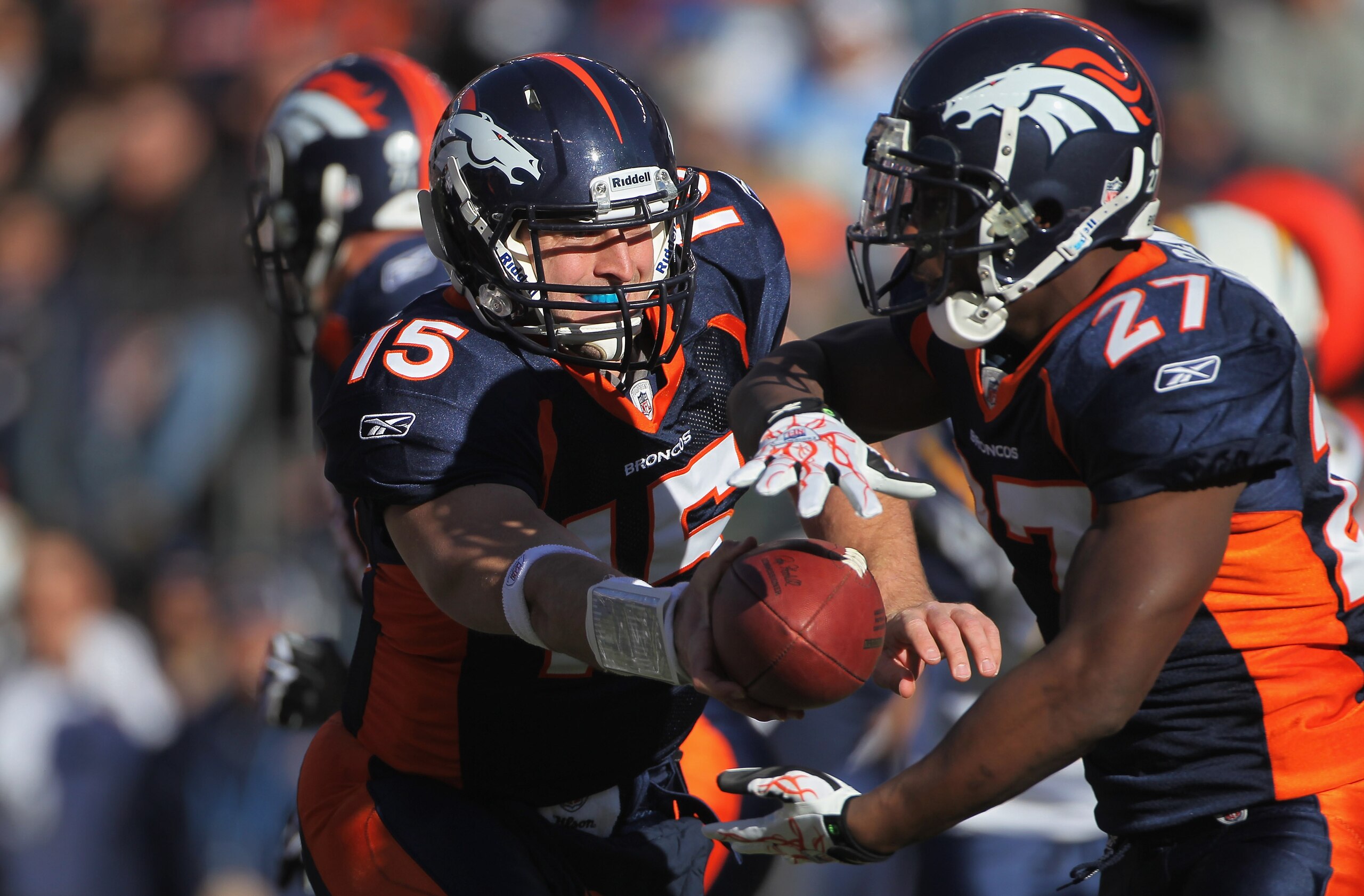 DENVER - JANUARY 02:  Quarterback Tim Tebow #15 of the Denver Broncos hands the ball off to running back Knowshon Moreno #27 against the San Diego Chargers at INVESCO Field at Mile High on January 2, 2011 in Denver, Colorado.  (Photo by Doug Pensinger/Get