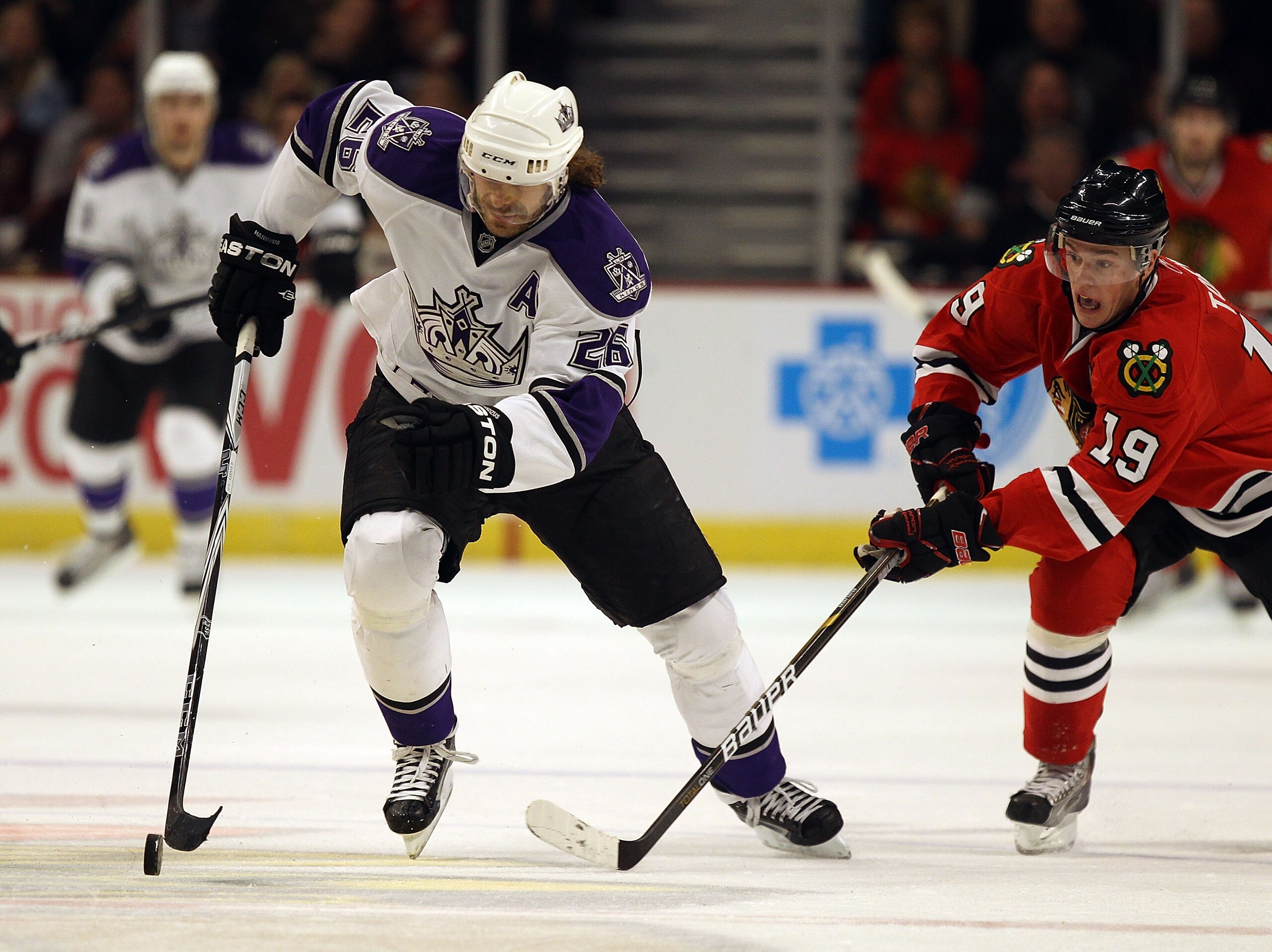 CHICAGO, IL - DECEMBER 19: Michal Handzus #26 of the Los Angeles Kings skates up the ice under pressure from Jonathan Toews #19 of the Chicago Blackhawks at the United Center on December 19, 2010 in Chicago, Illinois. The Blackhawks defeated the Kings 3-2