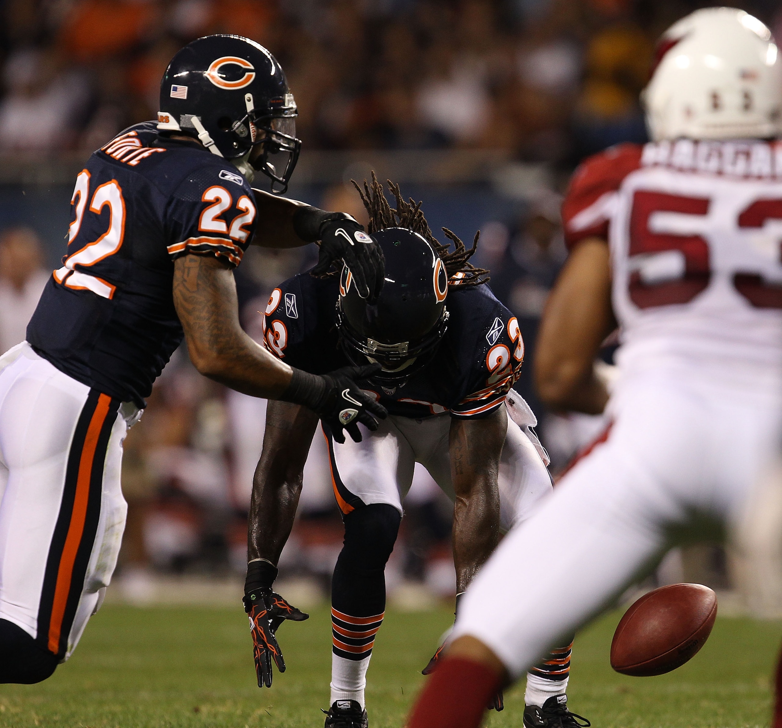 CHICAGO - AUGUST 28: Devin Hester #23 of the Chicago Bears fumbles the snap on a play in the 'wildcat' formation as teammate Matt Forte #22 moves to the ball against the Arizona Cardinals during a preseason game at Soldier Field on August 28, 2010 in Chic