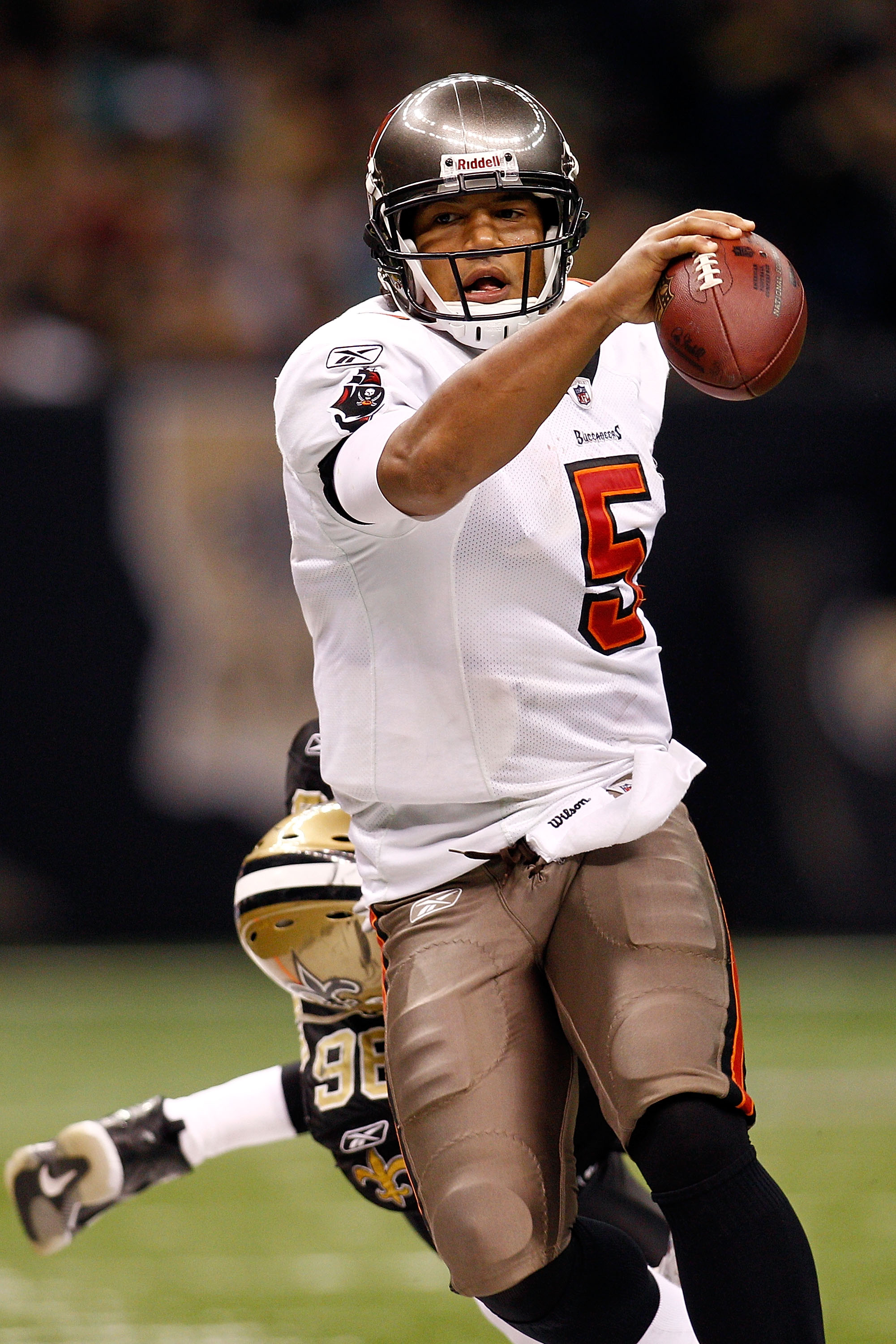 NEW ORLEANS, LA - JANUARY 02:  Quarterback Josh Freeman #5 of the Tampa Bay Buccaneers is pushed out of bounds by Alex Brown #96 of the New Orleans Saints at the Louisiana Superdome on January 2, 2011 in New Orleans, Louisiana.  The Buccaneers defeated th
