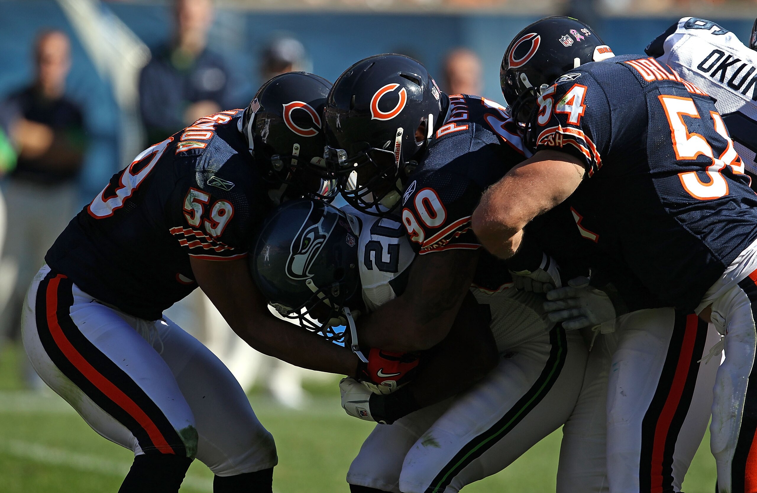 CHICAGO - OCTOBER 17: Justin Forsett #20 of the Seattle Seahawks is tackled by (L-R) Pia Tinoisamoa #59, Julius Peppers #90 and Brian Urlacher #54 of the Chicago Bears at Soldier Field on October 17, 2010 in Chicago, Illinois. The Seahawks defeated the Be