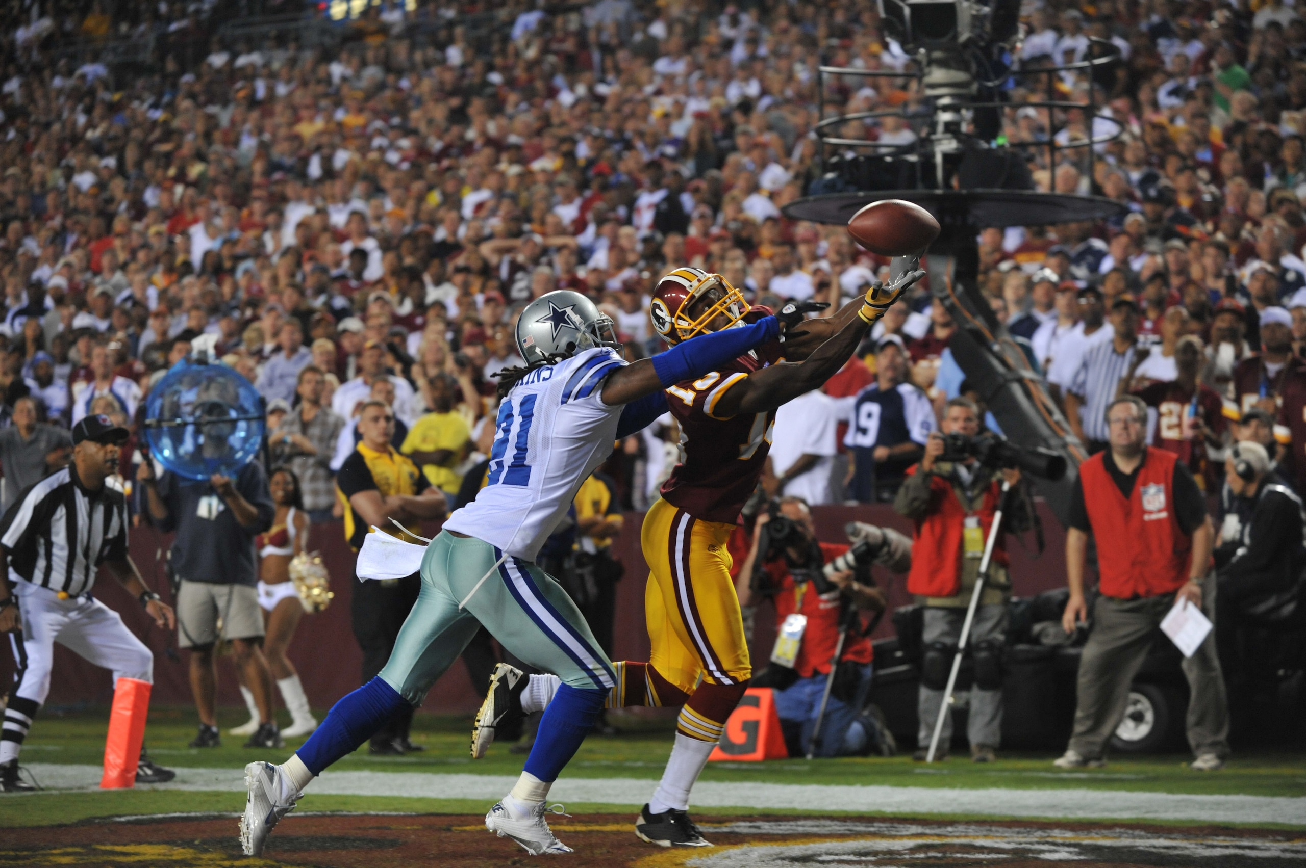 LANDOVER - SEPTEMBER 12:  Mike Jenkins #21 of the Dallas Cowboys knocks the ball loose from Anthony Armstrong #13 of the Washington Redskins during the NFL season opener at FedExField on September 12, 2010 in Landover, Maryland. The Redskins defeated the