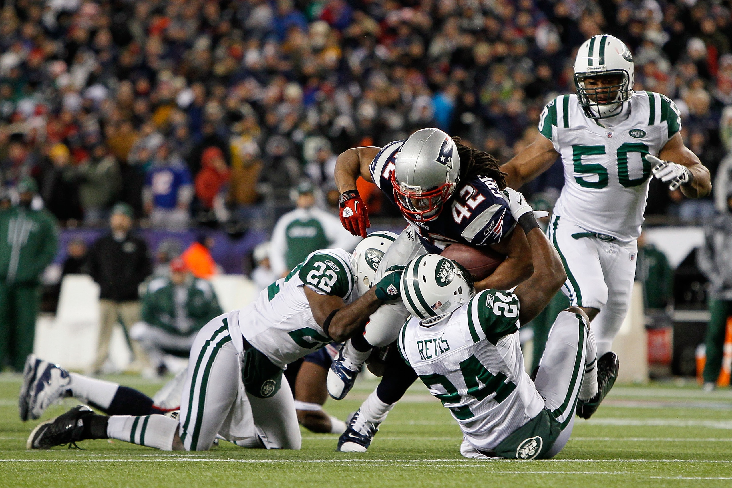 FOXBORO, MA - DECEMBER 06:  BenJarvus Green-Ellis #42 of the New England Patriots runs the ball against Darrelle Revis #24 and Brodney Pool #22 of the New York Jets at Gillette Stadium on December 6, 2010 in Foxboro, Massachusetts.  (Photo by Jim Rogash/G