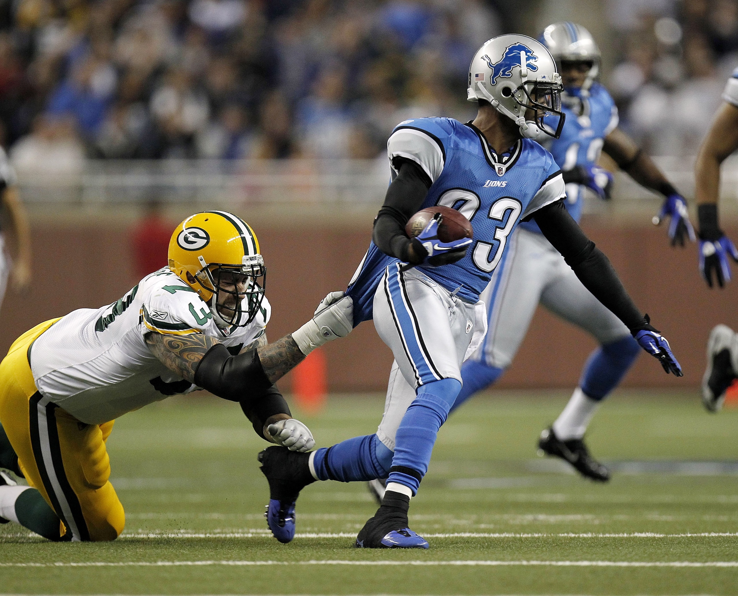 DETROIT, MI - DECEMBER 12: Chris Houston #23 of the Detroit Lions tries to get around the tackle after picking up a first quarter fumble of Daryn Colledge #73 of the Green Bay Packers on December 12, 2010 at Ford Field in Detroit, Michigan. (Photo by Gr DETROIT, MI - DECEMBER 12: Chris Houston #23 of the Detroit Lions tries to get around the tackle after picking up a first quarter fumble of Daryn Colledge #73 of the Green Bay Packers on December 12, 2010 at Ford Field in Detroit, Michigan. (Photo by Gr