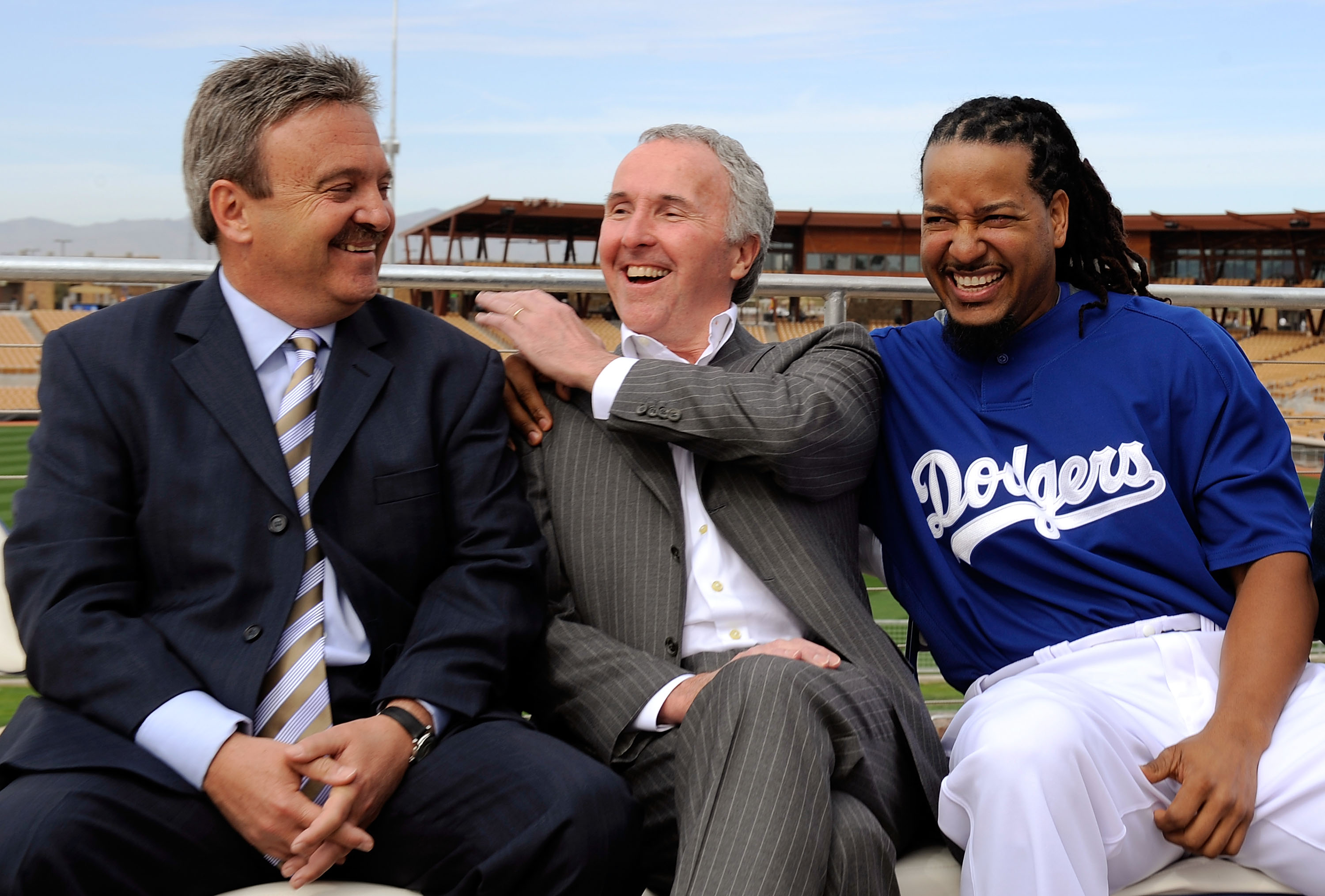 GLENDALE, AZ - MARCH 05:  Manny Ramirez#99 (R) hugs owner Frank McCourt as general manager Ned Colletti looks on during a news conference on March 5, 2009, at Camelback Ranch in Glendale, Arizona. Ramirez signed a $45 million two-year contract on Wednesda