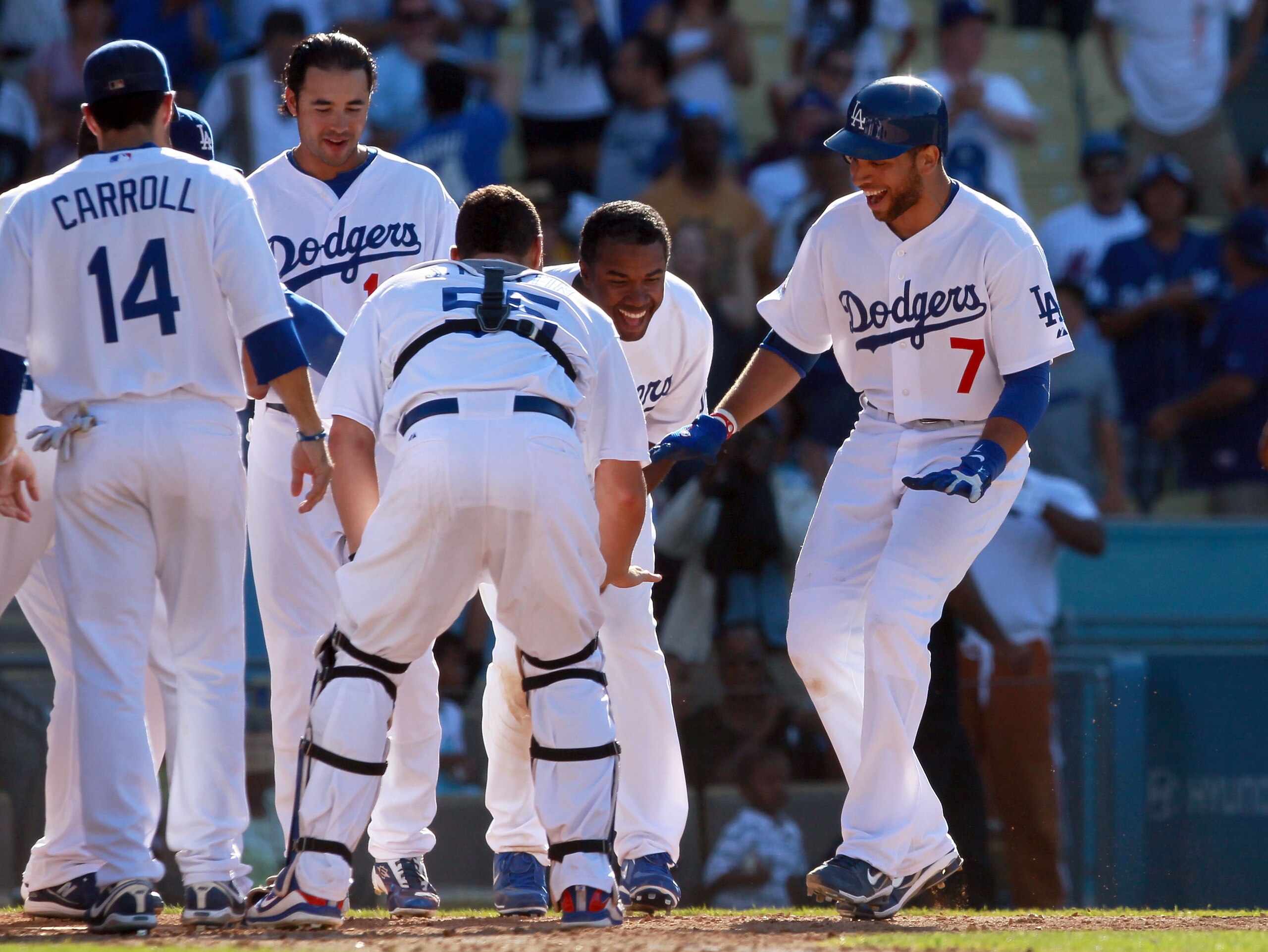 LOS ANGELES, CA - JULY 24:  James Loney (R) #7 of the Los Angeles Dodgers is congratulated by his teammates at home plate after hitting the game winning walk-off homerun in the 13th inning against the New York Mets at Dodger Stadium on July 24, 2010 in Lo