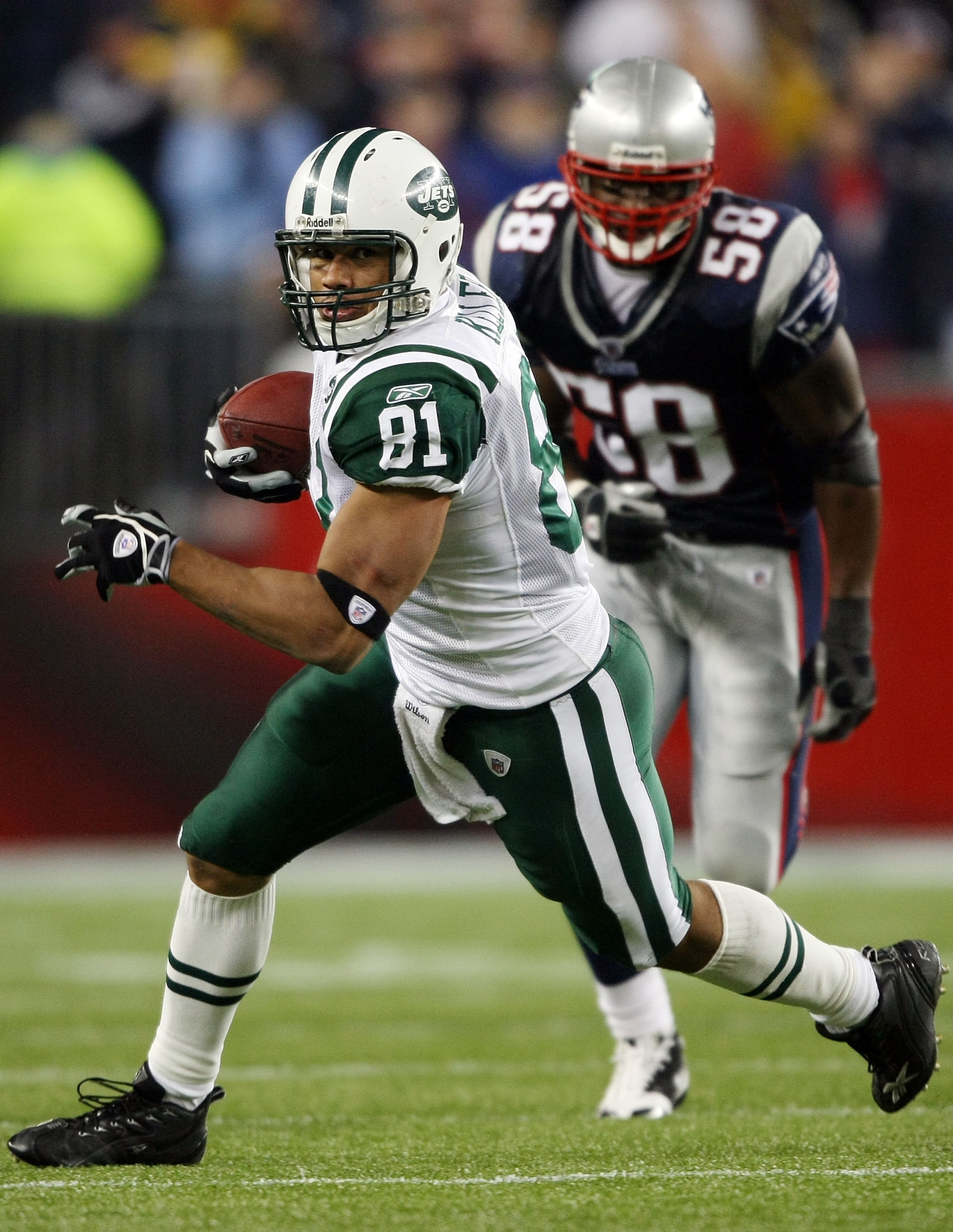 FOXBORO, MA - NOVEMBER 13:  Dustin Keller #81 of the New York Jets carries the ball in overtime as Pierre Woods #58 of the New England Patriots defends on November 13, 2008 at Gillette Stadium in Foxboro, Massachusetts. The Jets defeated the Patriots 34-3