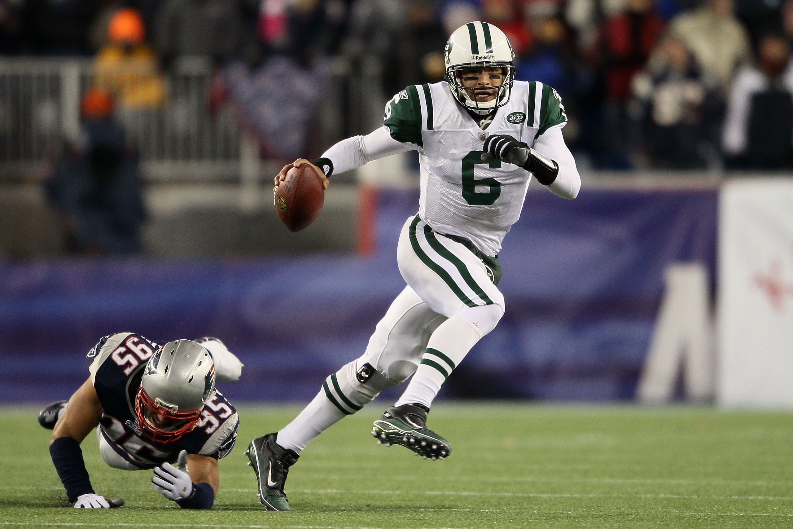 FOXBORO, MA - DECEMBER 06:  Mark Sanchez #6 of the New York Jets elludes the pass rush of Tully-Banta-Cain #95 of the New England Patriots at Gillette Stadium on December 6, 2010 in Foxboro, Massachusetts.  (Photo by Elsa/Getty Images)