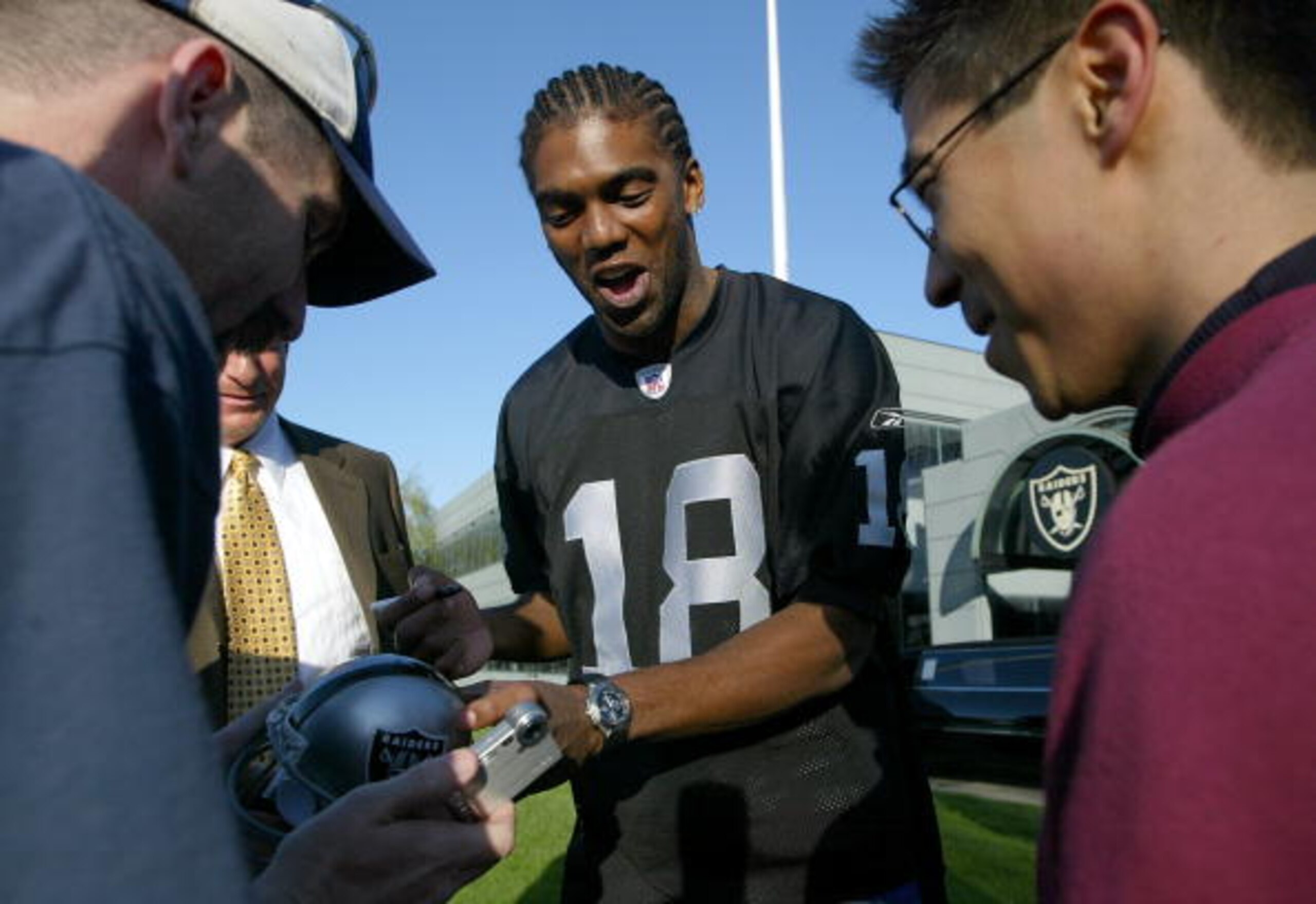 ALAMEDA, CA - MARCH 02:  New Oakland Raiders wide receiver Randy Moss #18 signs autographs after speaking at a news conference March 2, 2005 in Alameda, California. The former Minnesota Vikings was introduced by his new team today and the Raiders are work