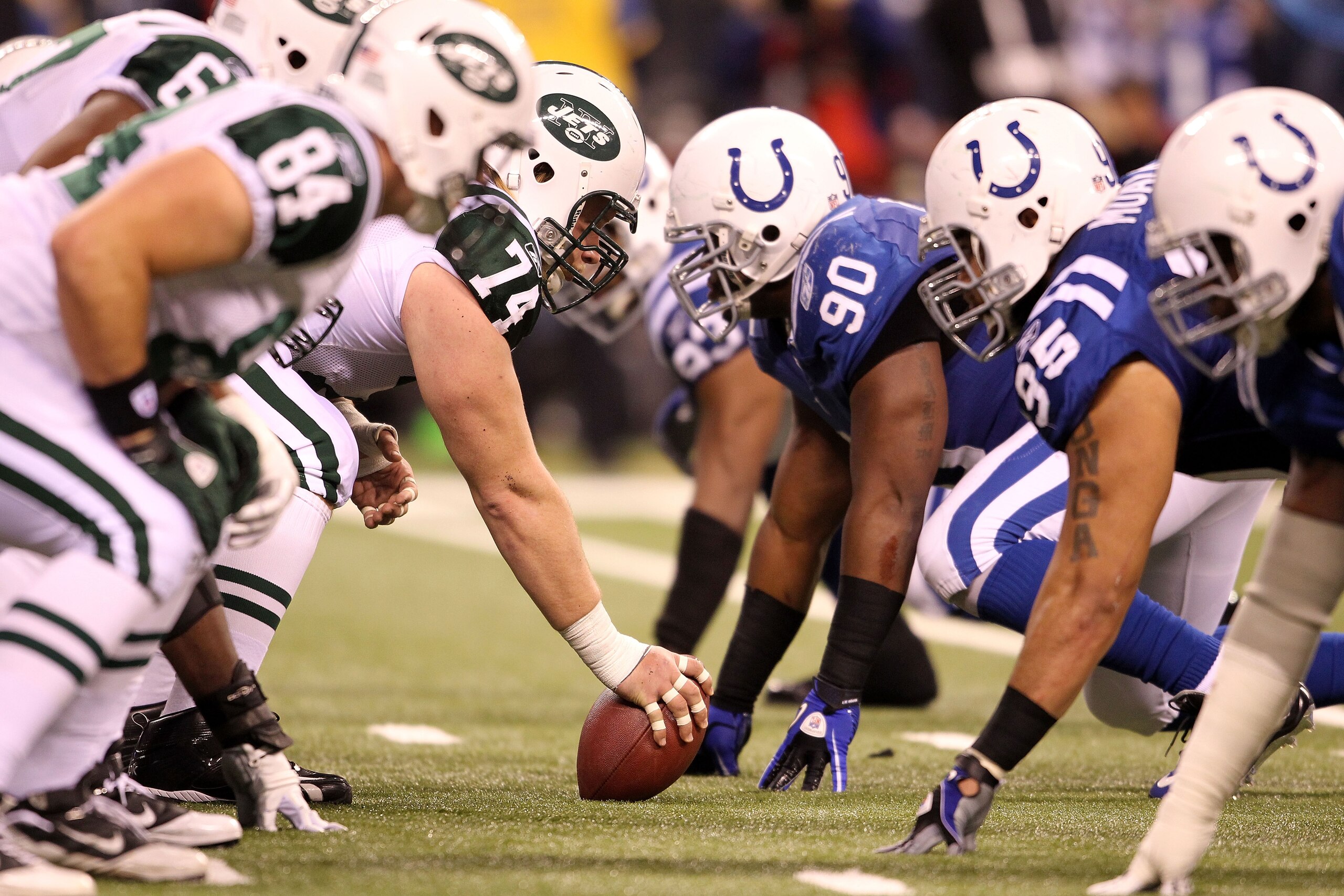 INDIANAPOLIS, IN - JANUARY 08:  Center Nick Mangold #74 of the New York Jets readies the ball for the snap against Dan Muir #90 of the Indianapolis Colts during their 2011 AFC wild card playoff game at Lucas Oil Stadium on January 8, 2011 in Indianapolis,