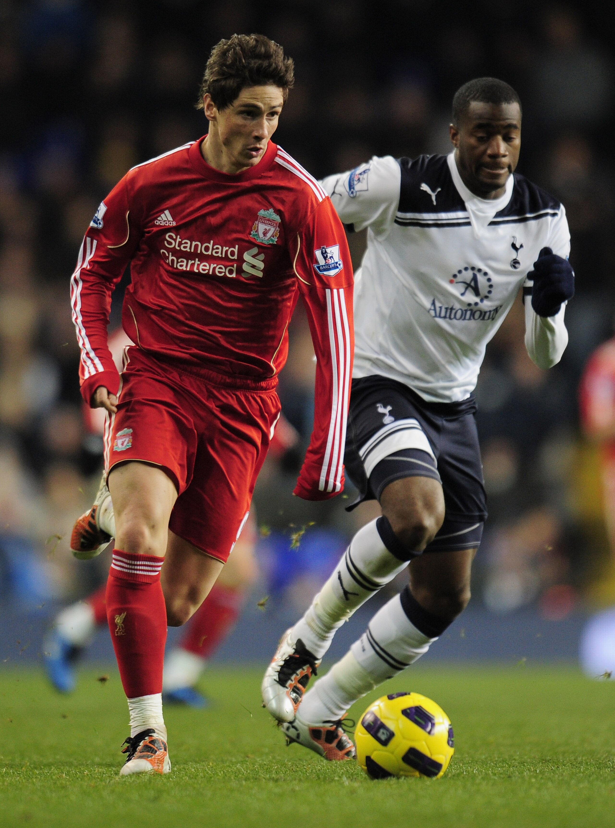 LONDON, ENGLAND - NOVEMBER 28:  Fernando Torres of Liverpool runs with the ball as he is closed down by Sebastien Bassong of Tottenham Hotspur during the Barclays Premier League match between Tottenham Hotspur and Liverpool at White Hart Lane on November