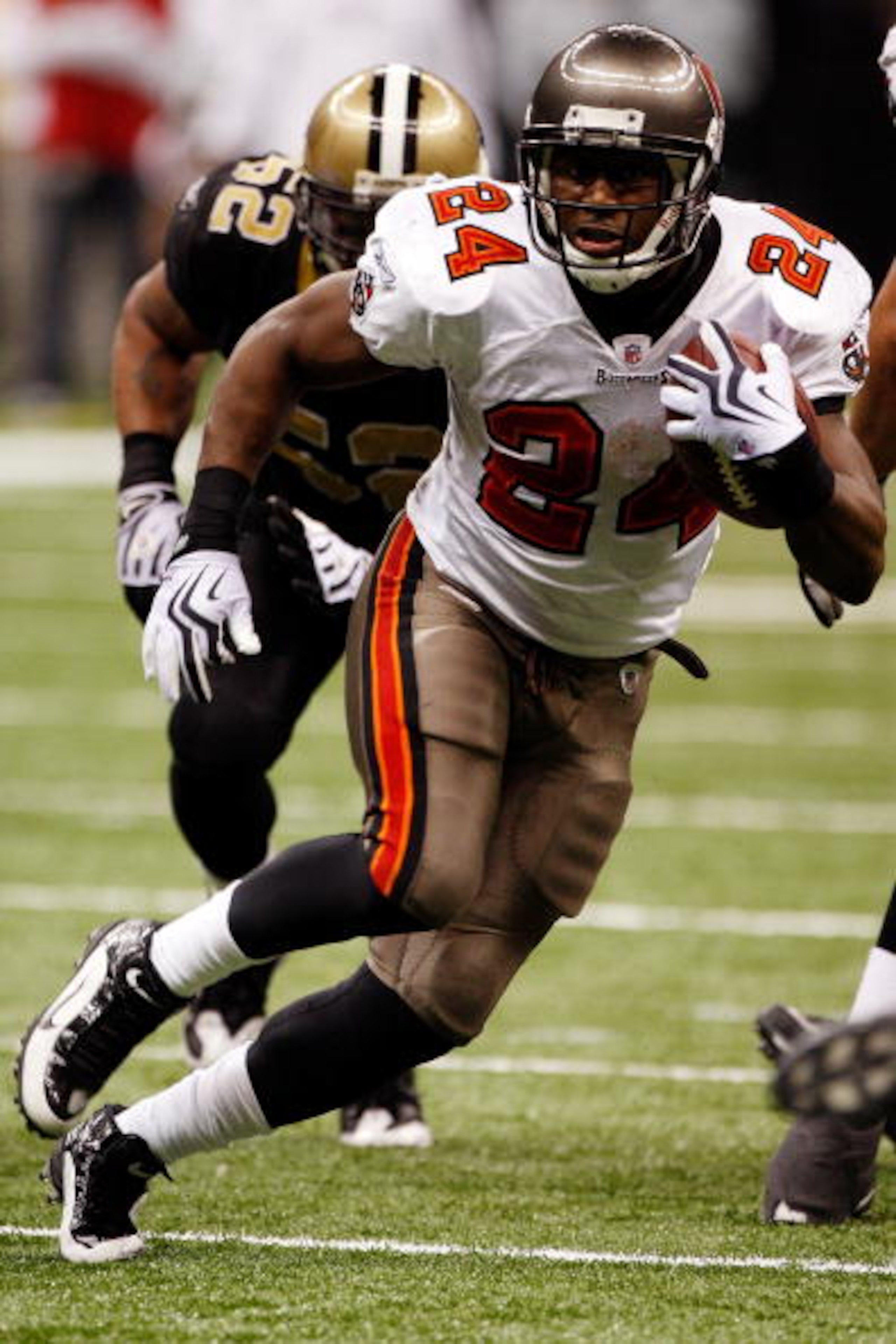 NEW ORLEANS - DECEMBER 27:  Cadillac Williams #24 of the Tampa Bay Buccaneers runs past Jonathan Casillas #52  of the New Orleans Saints at the Louisiana Superdome on December 27, 2009 in New Orleans, Louisiana.  (Photo by Chris Graythen/Getty Images)