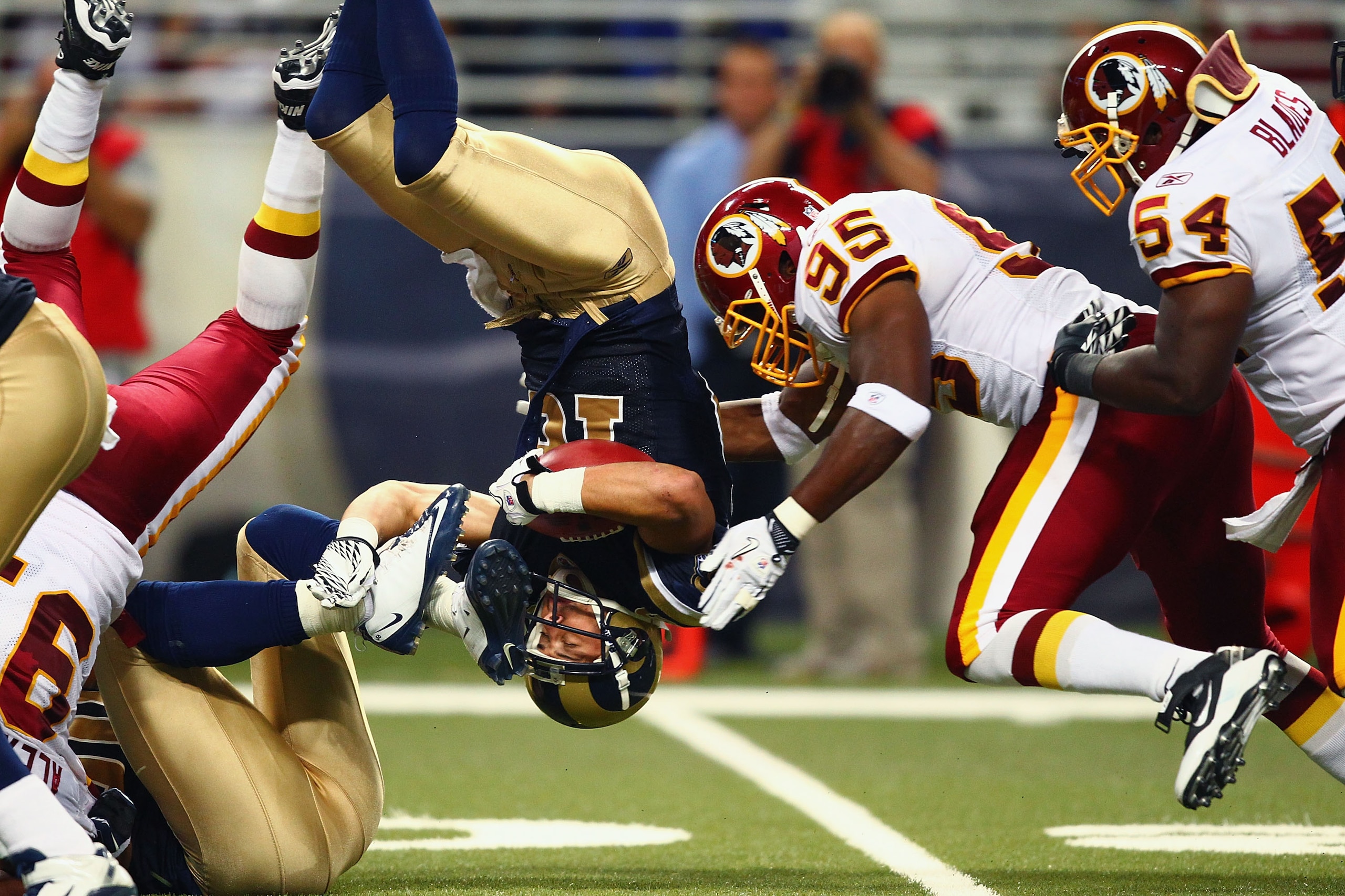 ST. LOUIS - SEPTEMBER 26: Danny Amendola #16 of the St. Louis Rams is flipped upside down against Chris Wilson #95 and H.B. Blades #54 both of the Washington Redskins at the Edward Jones Dome on September 26, 2010 in St. Louis, Missouri.  The Rams beat th