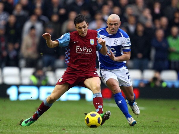 BIRMINGHAM, ENGLAND - JANUARY 16:  Stewart Downing of Villa holds off Stephen Carr of Birmingham during the Barclays Premier League match between Birmingham City and Aston Villa at St.Andrews on January 16, 2011 in Birmingham, England.  (Photo by Richard