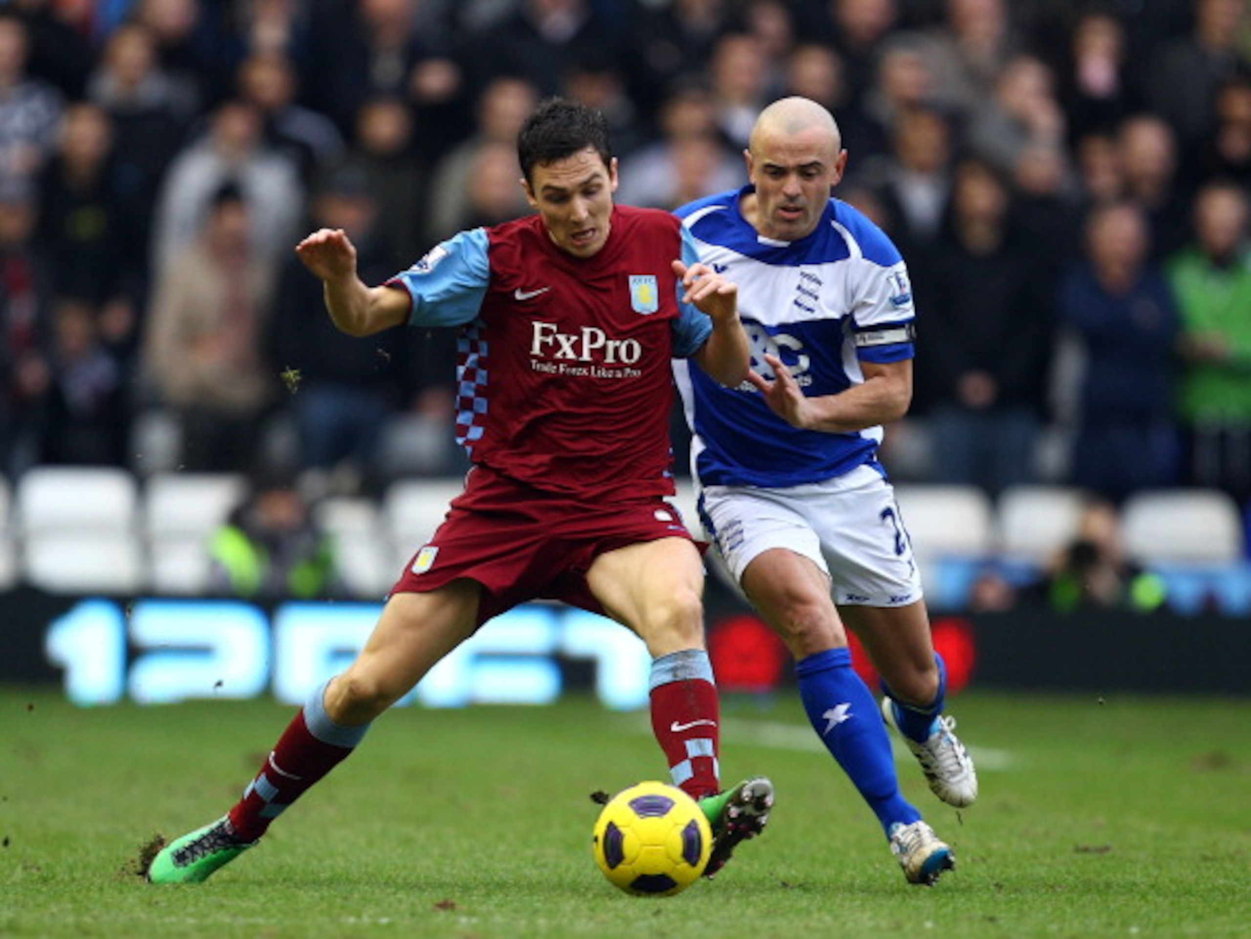 BIRMINGHAM, ENGLAND - JANUARY 16:  Stewart Downing of Villa holds off Stephen Carr of Birmingham during the Barclays Premier League match between Birmingham City and Aston Villa at St.Andrews on January 16, 2011 in Birmingham, England.  (Photo by Richard