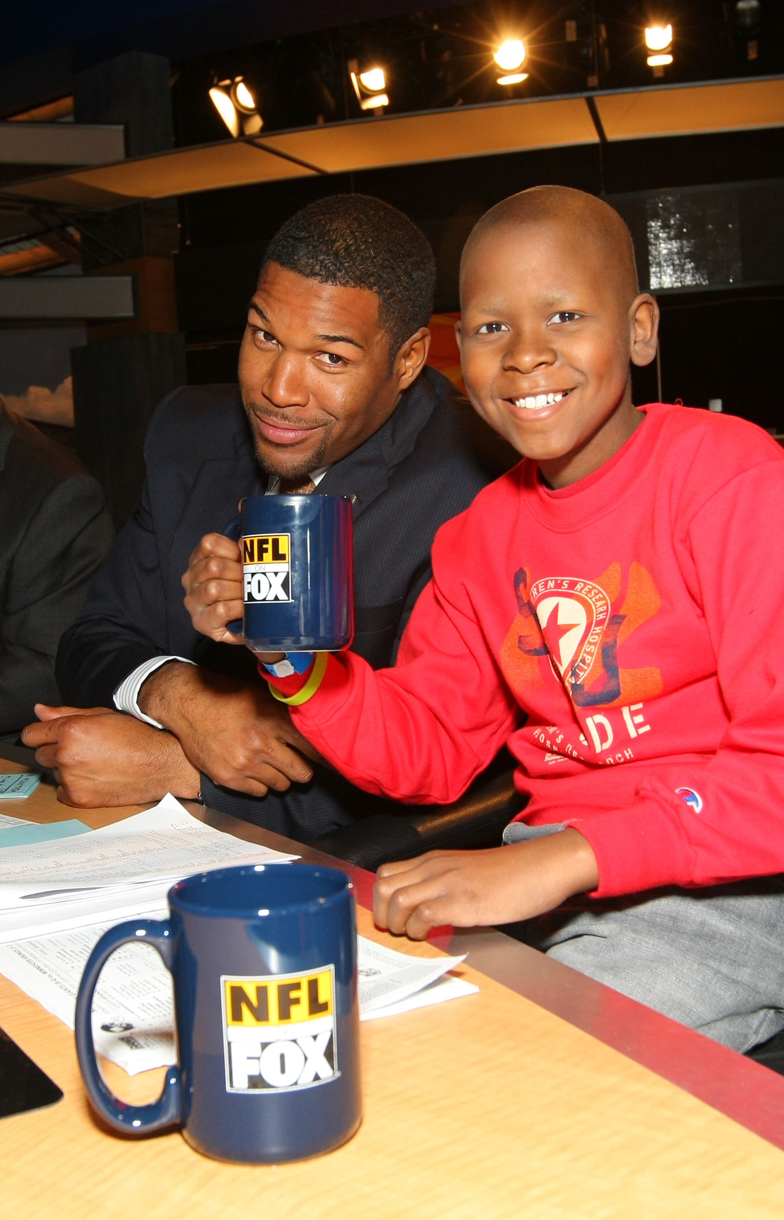 LOS ANGELES, CA - DECEMBER 12:  (L-R) FOX NFL Sunday analyst Michael Strahan and St. Jude Children's Research Hospital patient Markell share a moment during a break on the set of FOX NFL Sunday on December 12, 2010 in Los Angeles, United States.  (Photo b