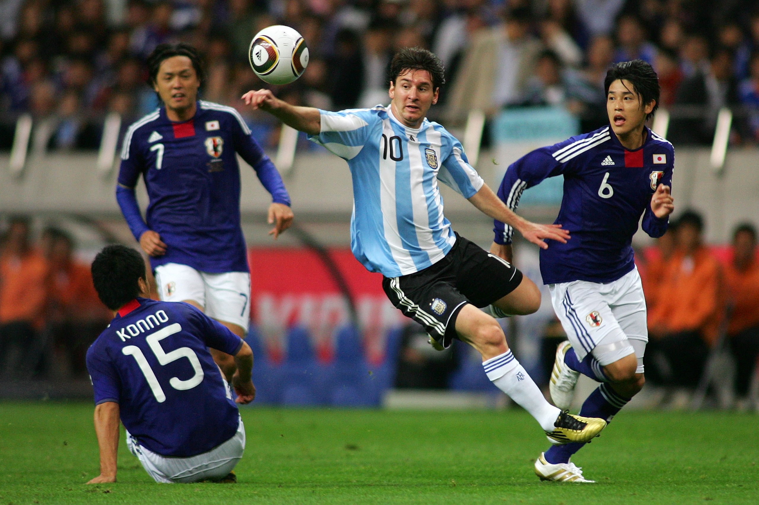 SAITAMA, JAPAN - OCTOBER 08: Lionel Messi  of Argentina  and Atsuto Uchida of Japan compete for the ball during  the International Friendly match between Japan and Argentina at Saitama Stadium on October 8, 2010 in Saitama, Japan. (Photo by Koji Watanabe/