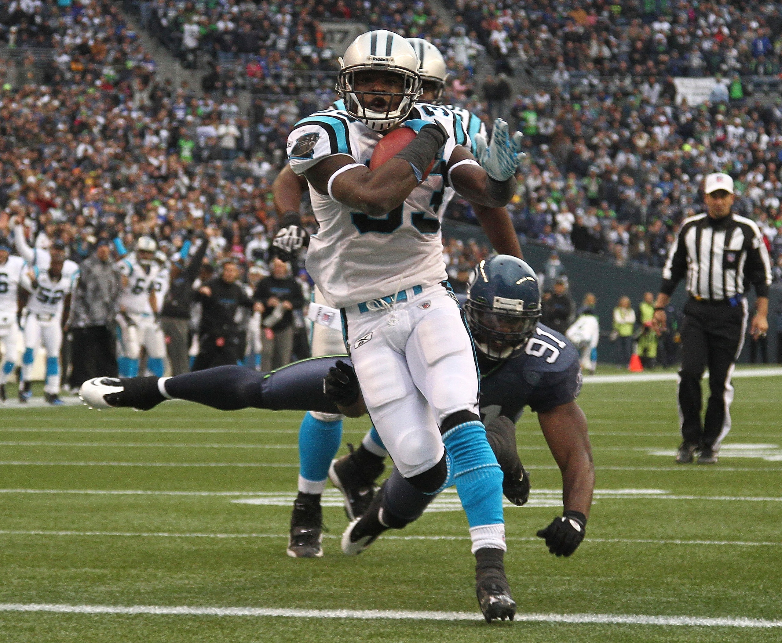 SEATTLE, WA - DECEMBER 05:  Running back Mike Goodson #33 of the Carolina Panthers rushes for a touchdown against Chris Clemons #91 of the Seattle Seahawks at Qwest Field on December 5, 2010 in Seattle, Washington. (Photo by Otto Greule Jr/Getty Images)