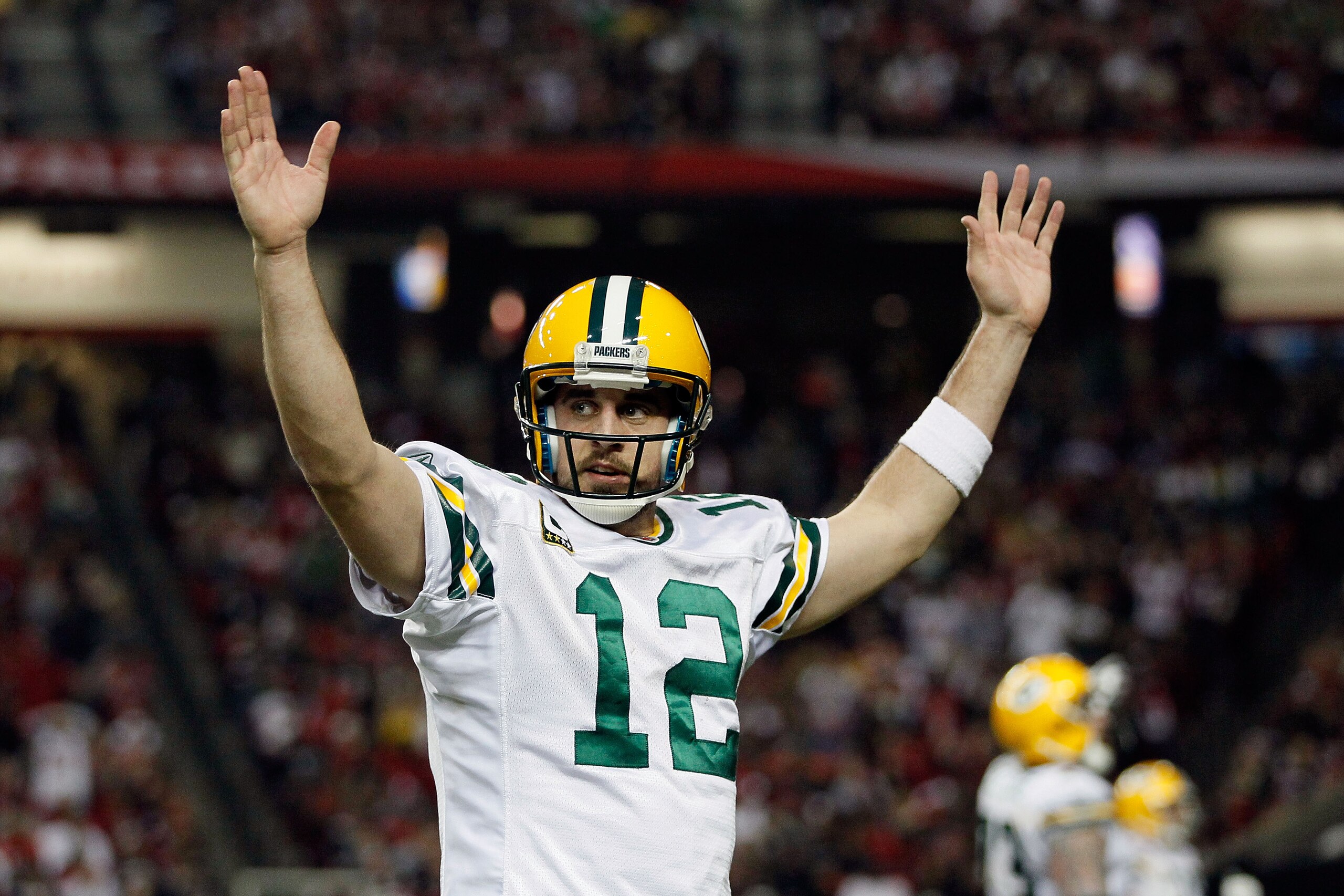 ATLANTA, GA - JANUARY 15:  Aaron Rodgers #12 of the Green Bay Packers reacts after he threw a 7-yard touchdown to John Kuhn #30 in the third quarter against the Atlanta Falcons during their 2011 NFC divisional playoff game at Georgia Dome on January 15, 2