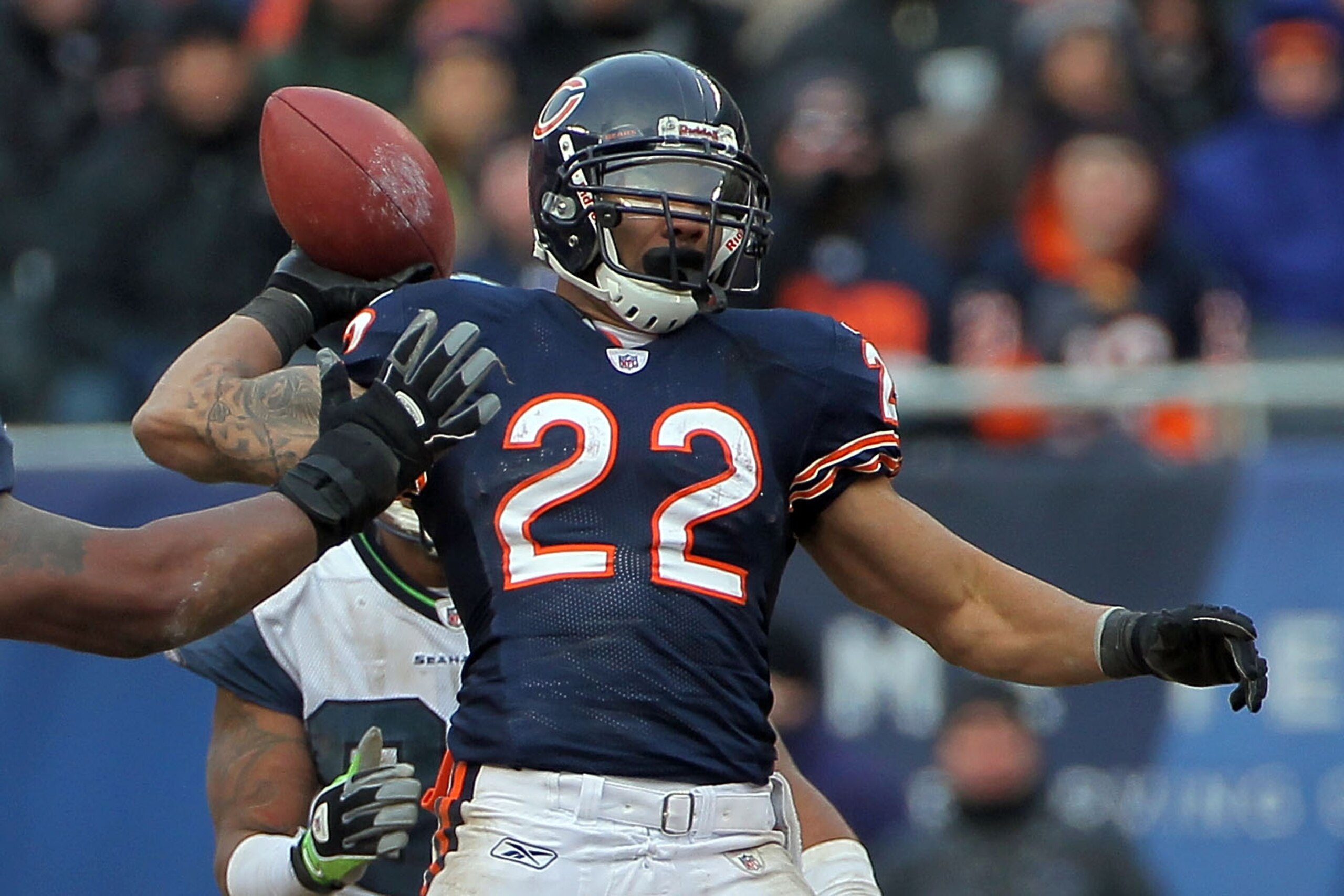 CHICAGO, IL - JANUARY 16:  Running back Matt Forte #22 of the Chicago Bears throws a pass over the arm of Kentwan Balmer #95 of the Seattle Seahawks as the pass is intercepted by Aaron Curry #59 in the second half of the 2011 NFC divisional playoff game a