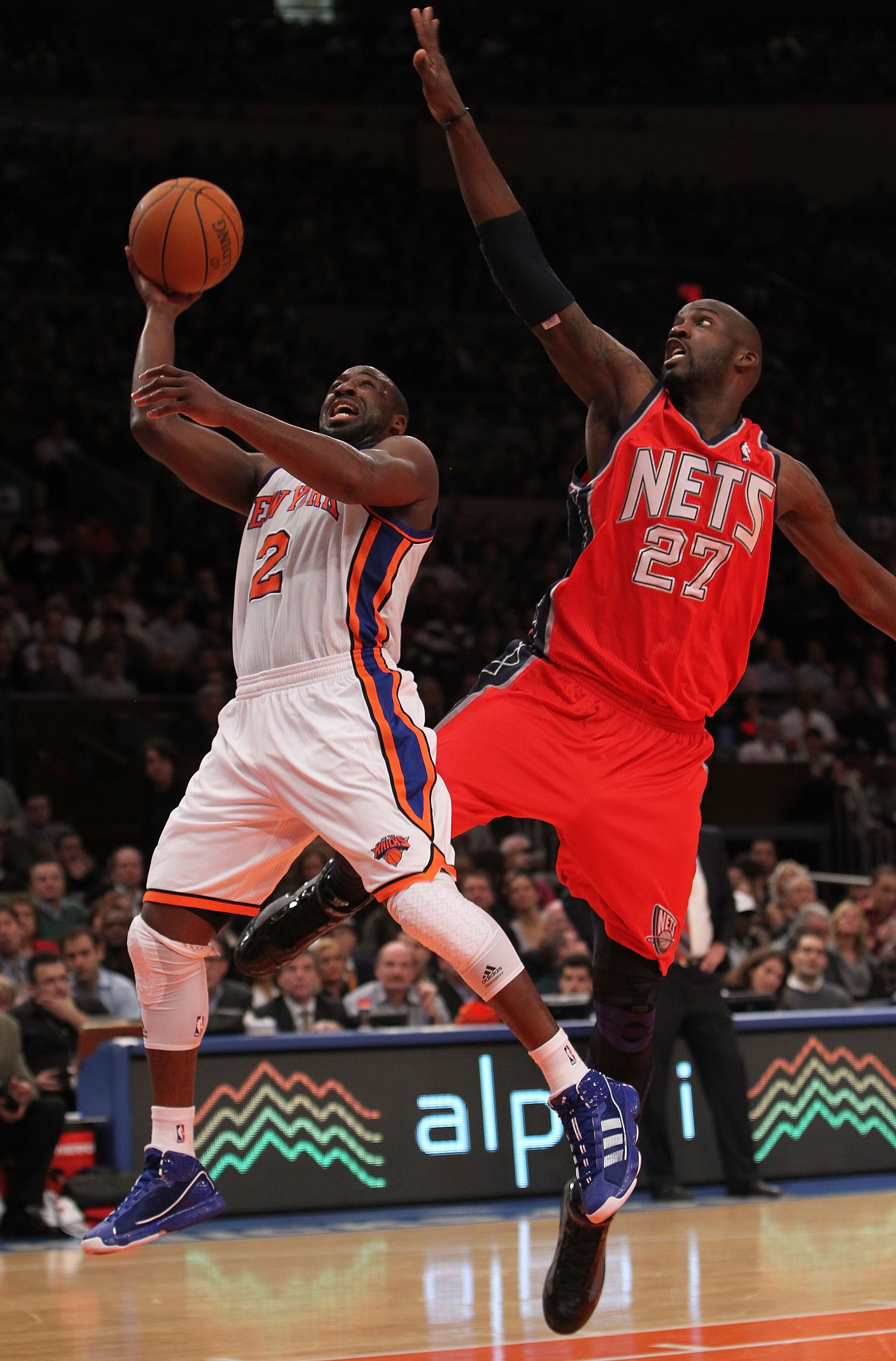 NEW YORK, NY - NOVEMBER 30:  Raymond Felton #2 of the New York Knicks shoots the ball under the block of Johan Petro #27 of the New Jersey Nets on November 30, 2010 at Madison Square Garden in New York City. NOTE TO USER: User expressly acknowledges and a