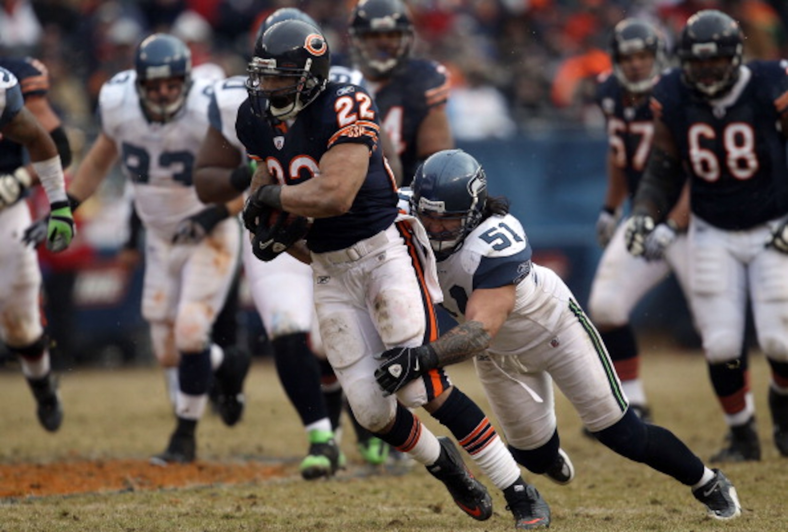 CHICAGO, IL - JANUARY 16:  Running back Matt Forte #22 of the Chicago Bears runs the ball as Lofa Tatupu #51 of the Seattle Seahawks attempts to tackle him from behind in the 2011 NFC divisional playoff game at Soldier Field on January 16, 2011 in Chicago