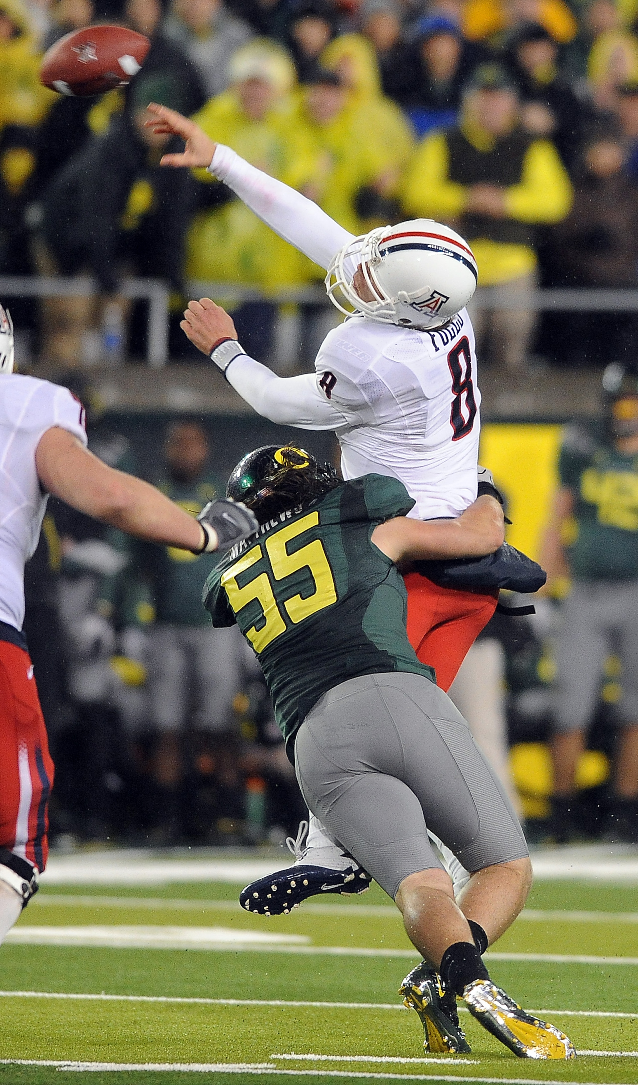 EUGENE, OR - NOVEMBER 26: Quarterback Nick Foles #8 of the Arizona Wildcats is hit by linebacker Casey Matthews #55 of the Oregon Ducks in the third quarter of the game at Autzen Stadium on November 26, 2010 in Eugene, Oregon. The Ducks won the game 48-29