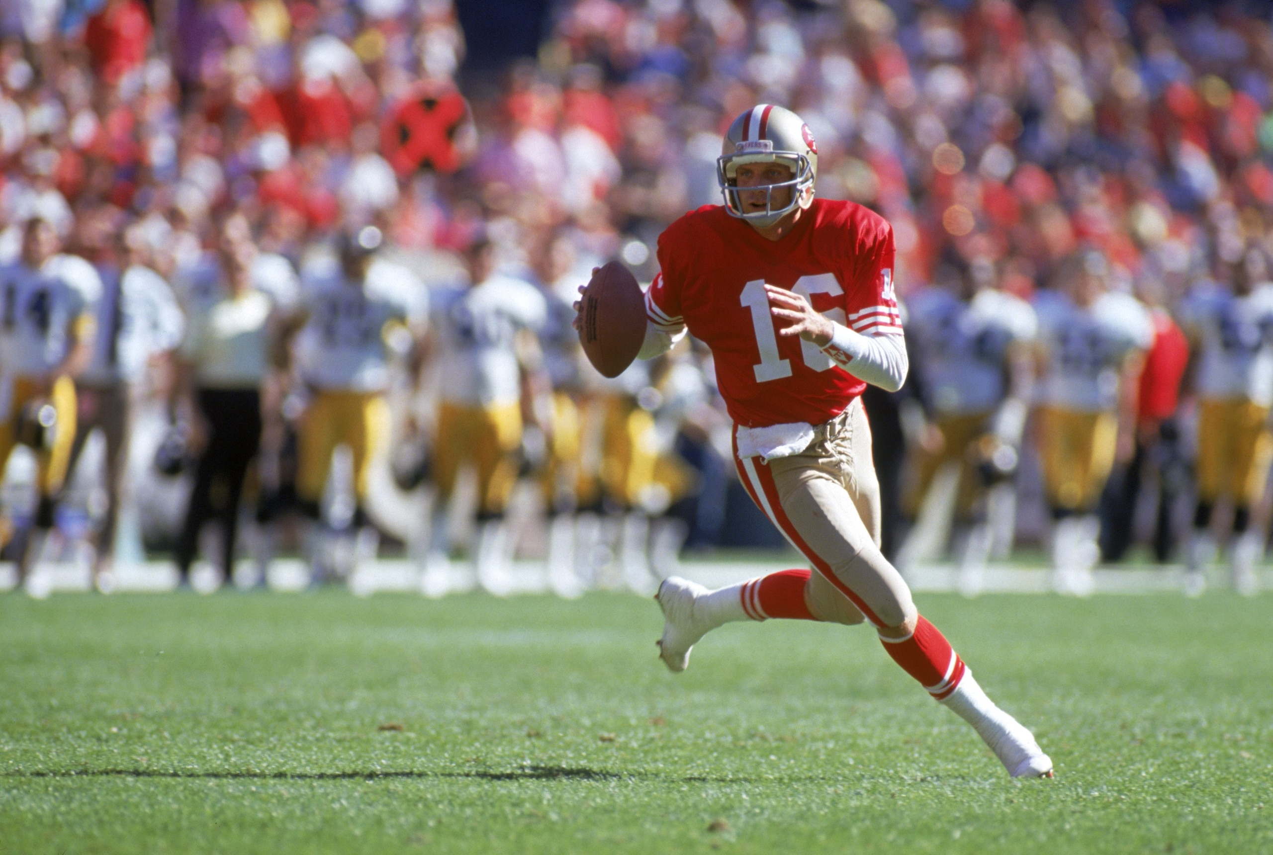 SAN FRANCISCO - OCTOBER 21:  Quarterback Joe Montana #16 of the San Francisco 49ers runs with the ball as he looks downfield for a receiver during a game against the Pittsburgh Steelers at Candlestick Park on October 21, 1990 in San Francisco, California.