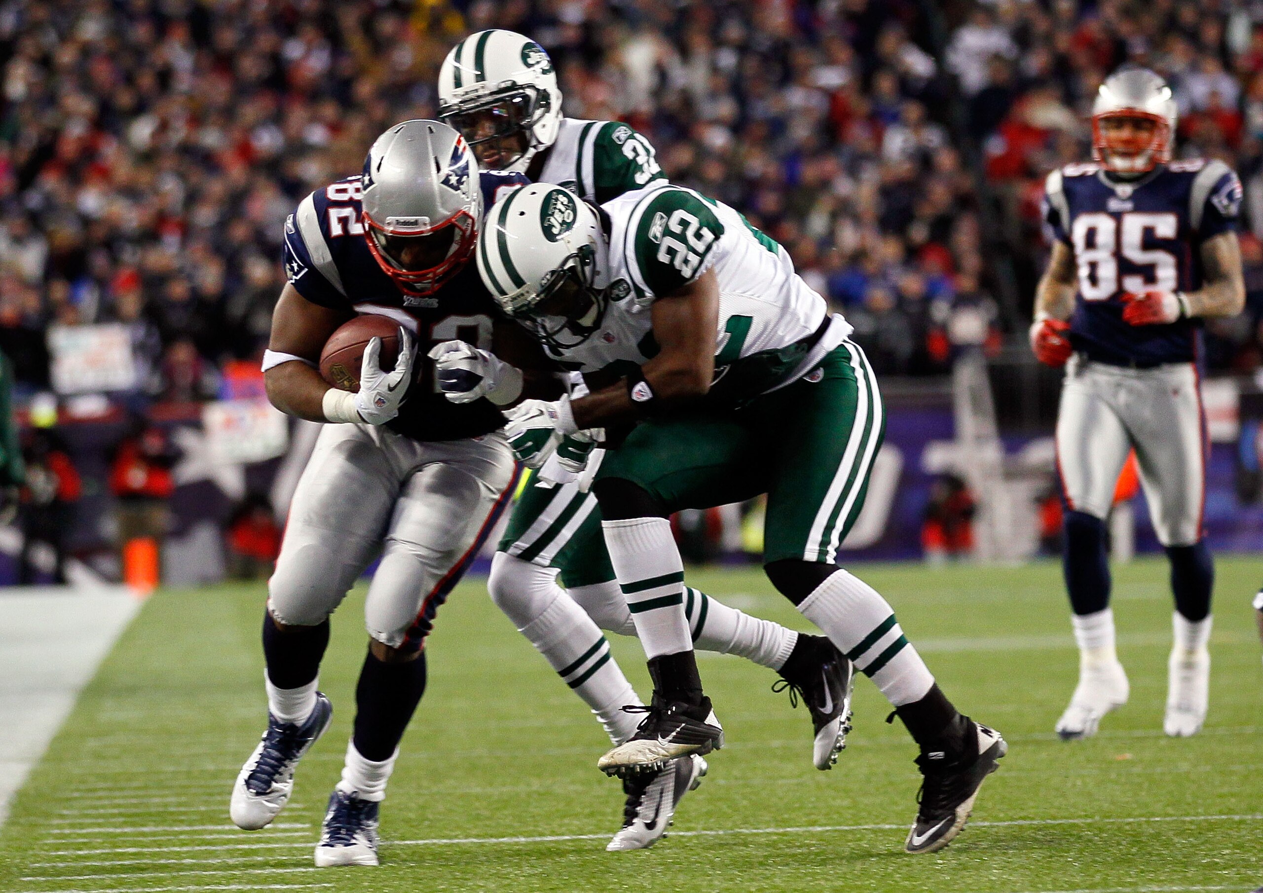 FOXBORO, MA - JANUARY 16:  Alge Crumpler #82 of the New England Patriots tries to avoid the tackle of Brodney Pool #22 of the New York Jets during their 2011 AFC divisional playoff game at Gillette Stadium on January 16, 2011 in Foxboro, Massachusetts.  (