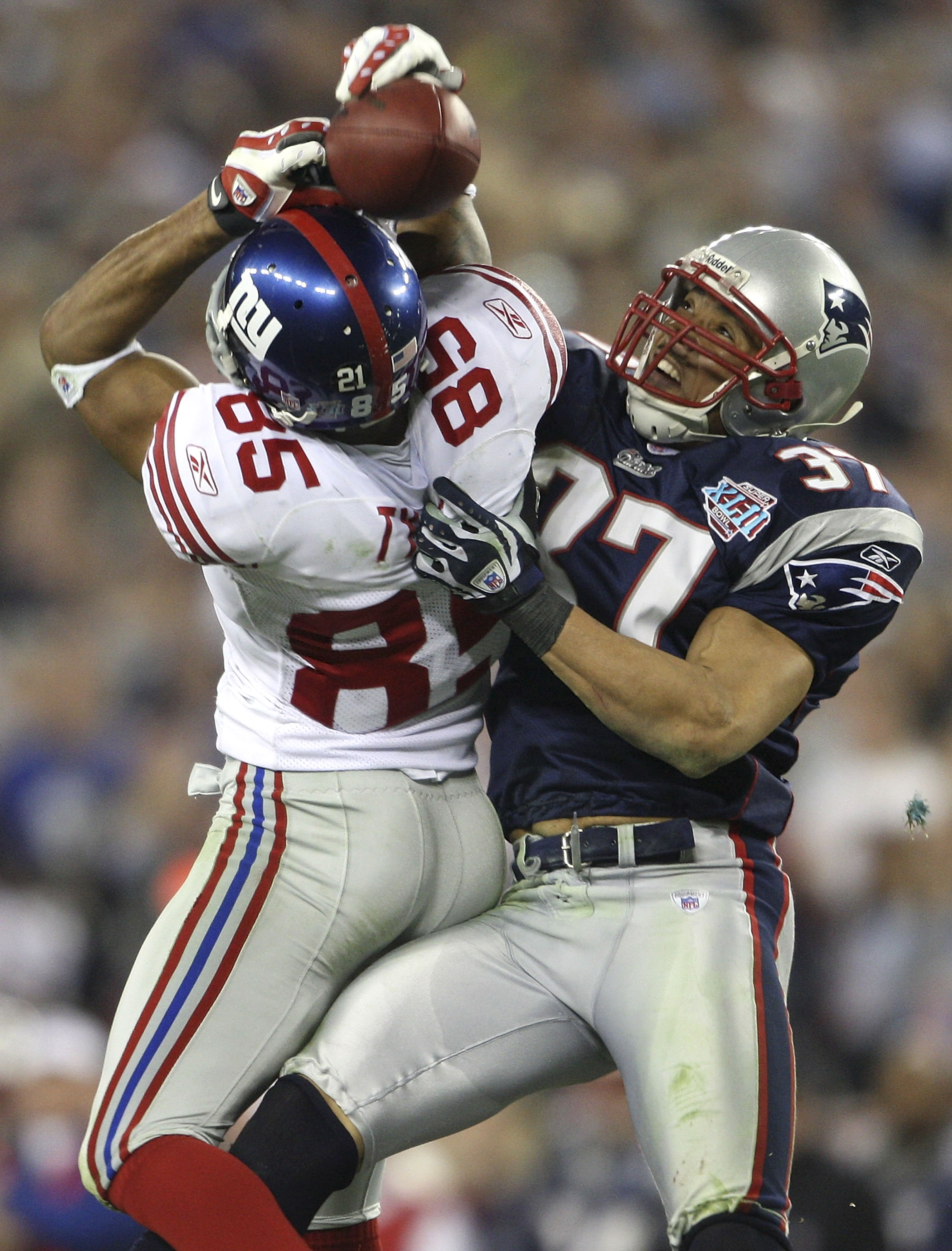GLENDALE, AZ - FEBRUARY 03:  David Tyree #85 of the New York Giants catches a 32-yard pass from Eli Manning #10 as Rodney Harrison #37 of the New England Patriots attempts to knock it out in the fourth quarter of Super Bowl XLII on February 3, 2008 at the