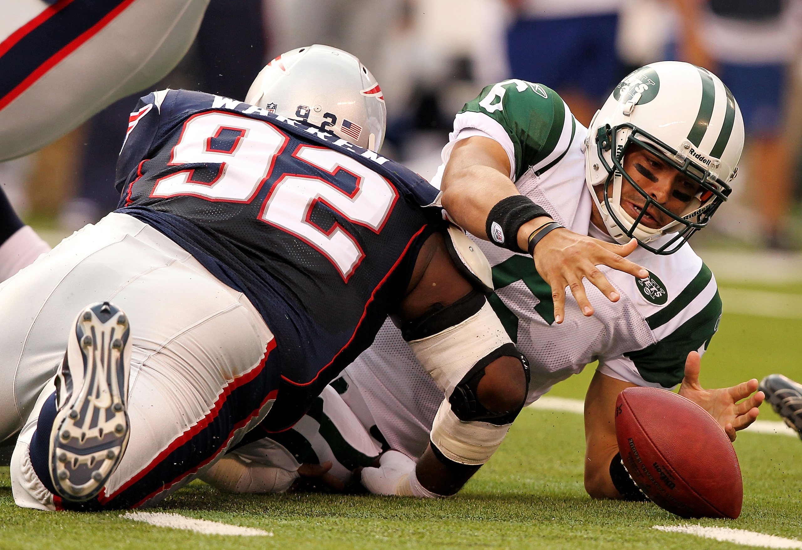 EAST RUTHERFORD, NJ - SEPTEMBER 19:  Mark Sanchez #6  of the New York Jets fumbles the ball after being sacked by Gerard Warren #92 of the New England Patriots during their  game on September 19, 2010 at the New Meadowlands Stadium  in East Rutherford, Ne