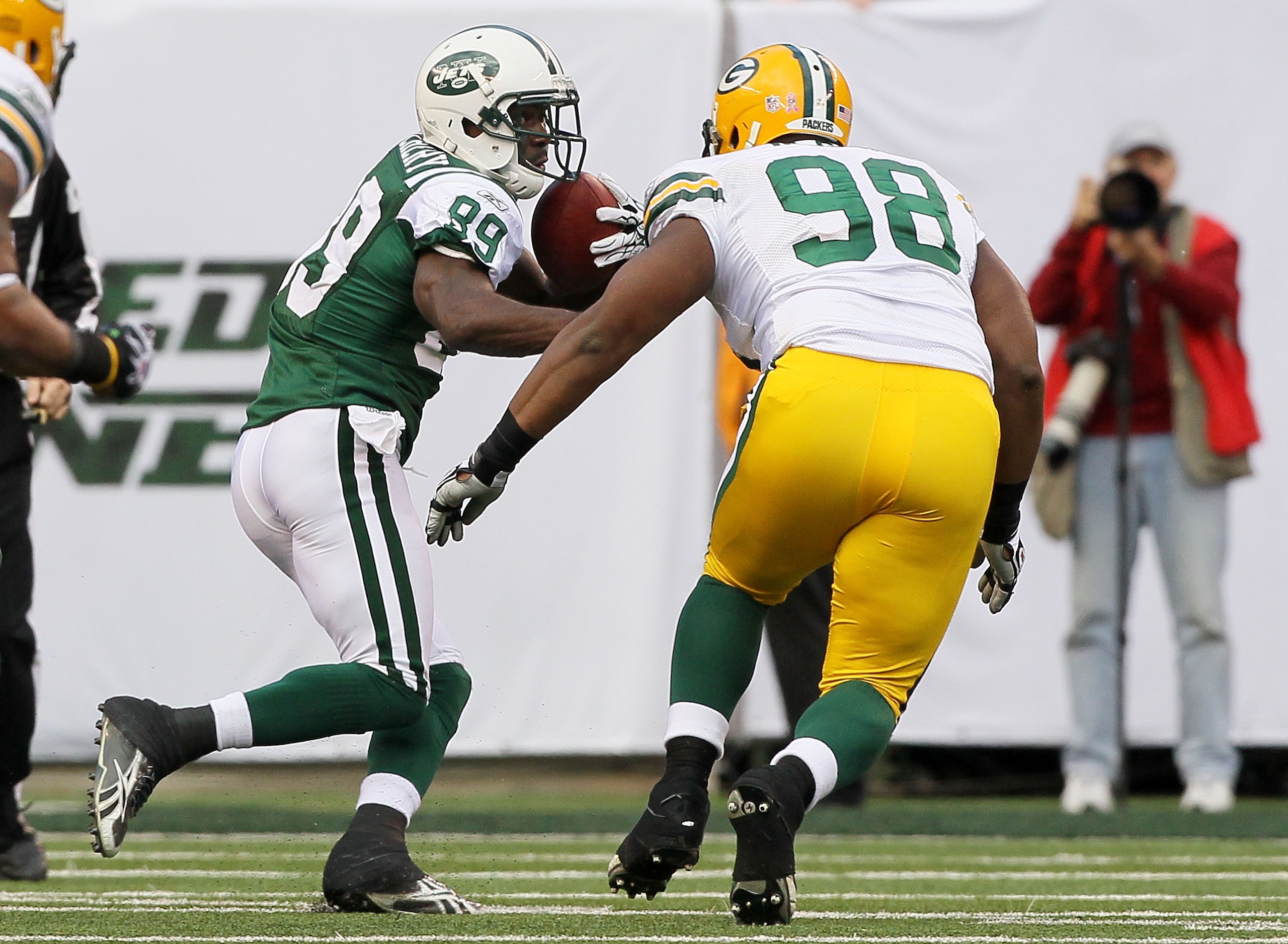 EAST RUTHERFORD, NJ - OCTOBER 31:  Jerricho Cotchery #89 of the New York Jets looks for room to run against C.J. Wilson #98 of the Green Bay Packers on October 31, 2010 at the New Meadowlands Stadium in East Rutherford, New Jersey. The Packers defeated th