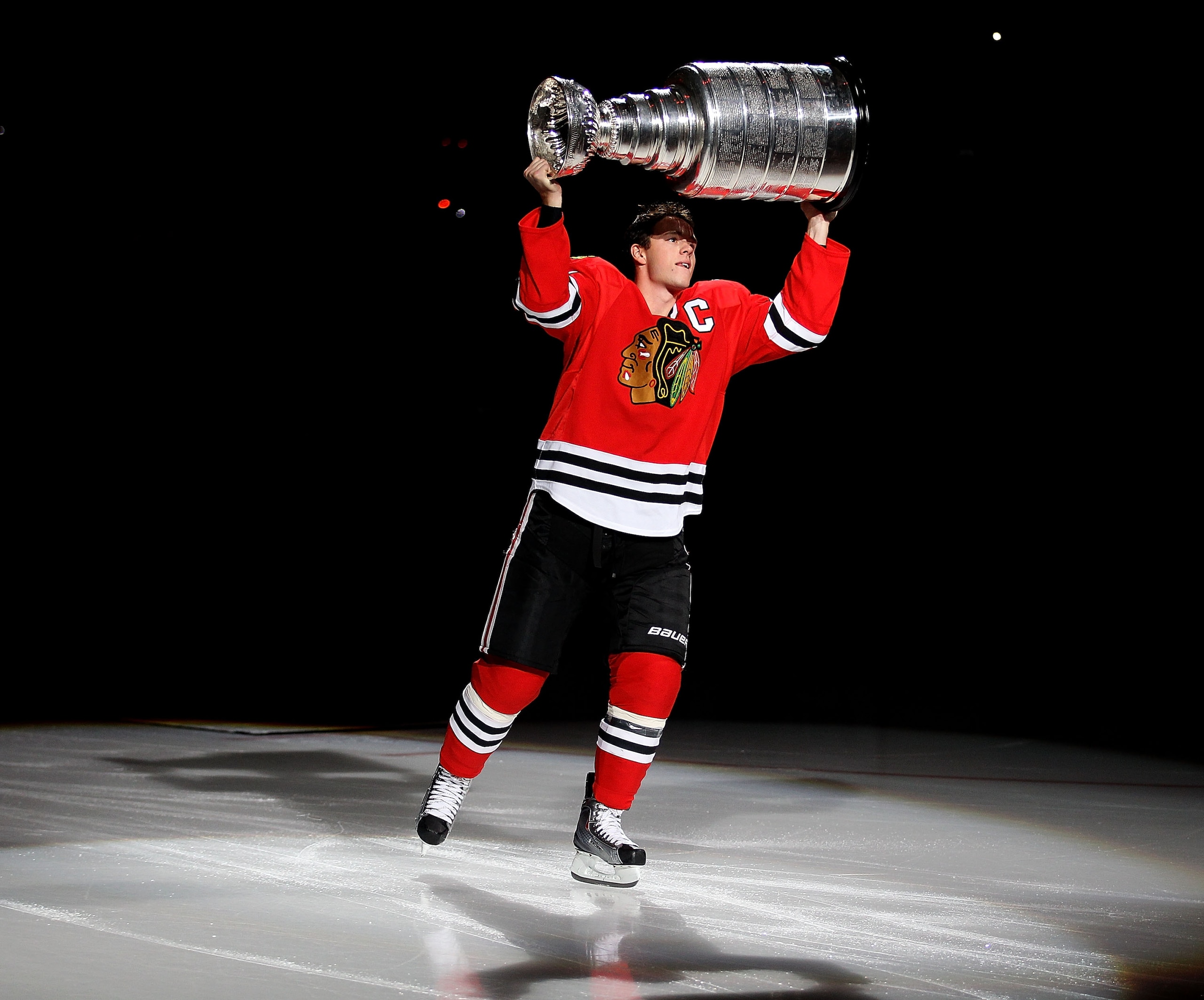 CHICAGO - OCTOBER 09: Jonathan Toews #19 of the Chicago Blackhawks carries the Stanley Cup across the ice in a ceremony before the Blackhawks season home opening game against the Detroit Red Wings at the United Center on October 9, 2010 in Chicago, Illino