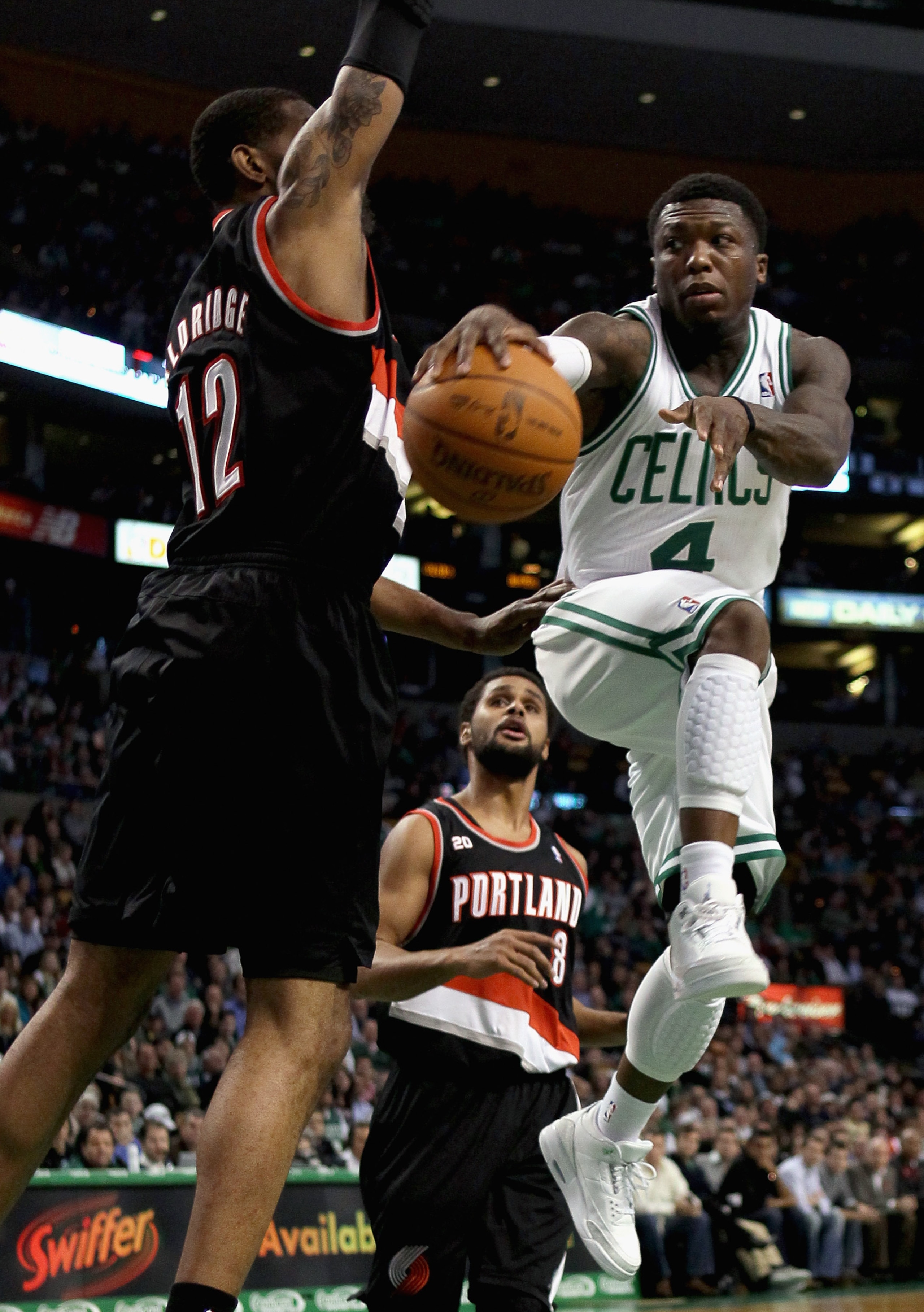 BOSTON - DECEMBER 01:  Nate Robinson #4 of the Boston Celtics passes the ball as LaMarcus Aldridge #12 of the Portland Trailblazers defends on December 1, 2010 at the TD Garden in Boston, Massachusetts.  NOTE TO USER: User expressly acknowledges and agree