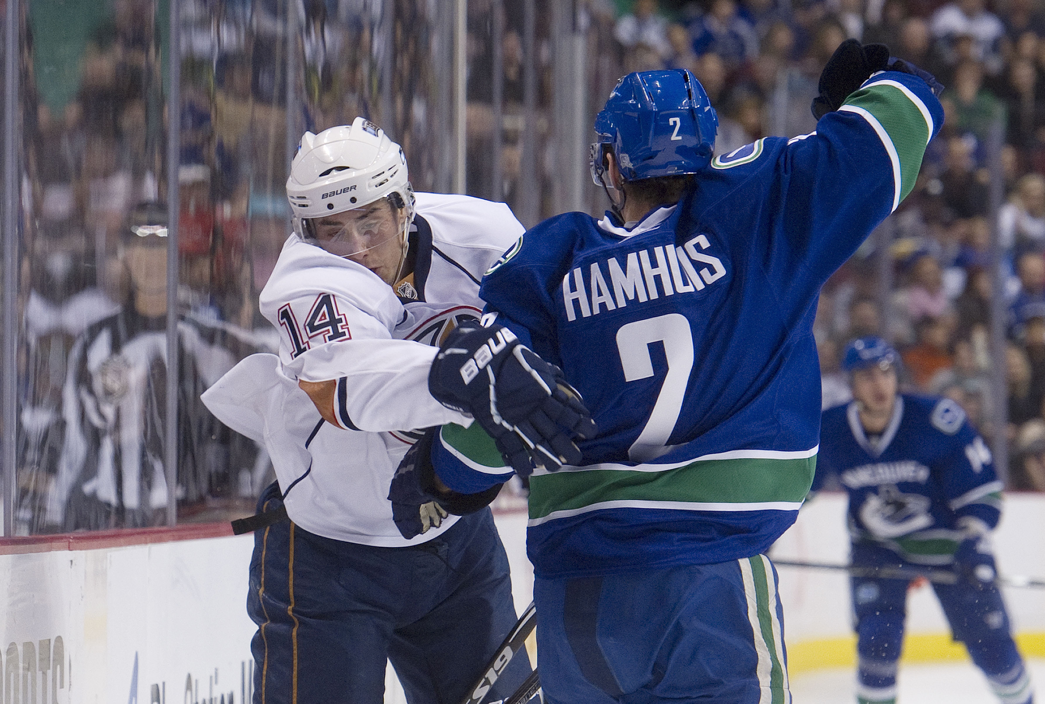 VANCOUVER, CANADA - DECEMBER 26: Dan Hamhuis #2 of the Vancouver Canucks interferes with Jordan Eberle #14 of the Edmonton Oilers and receives a minor penalty during the first period in NHL action on December 26, 2010 at Rogers Arena in Vancouver, BC, Can