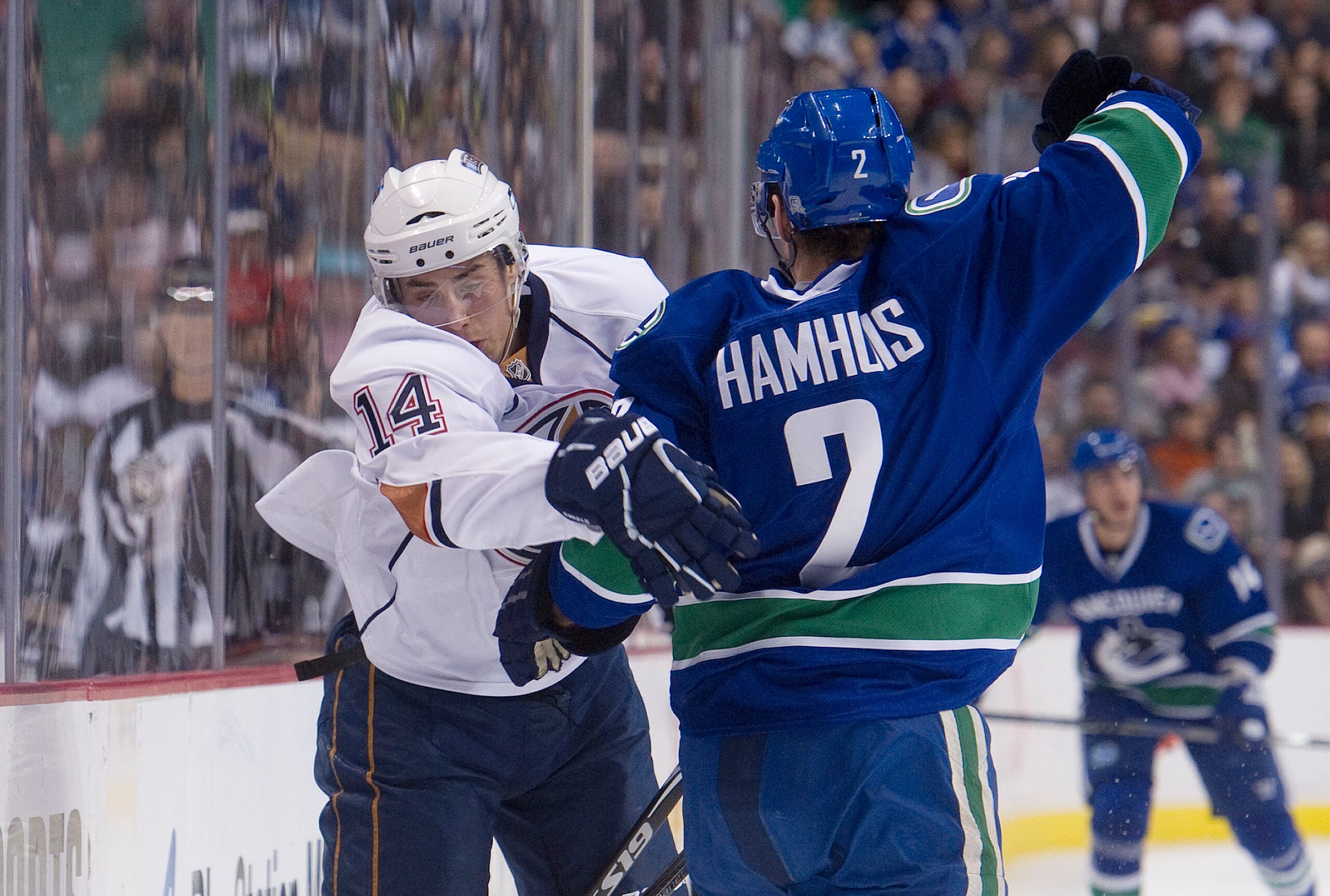 VANCOUVER, CANADA - DECEMBER 26: Dan Hamhuis #2 of the Vancouver Canucks interferes with Jordan Eberle #14 of the Edmonton Oilers and receives a minor penalty during the first period in NHL action on December 26, 2010 at Rogers Arena in Vancouver, BC, Can
