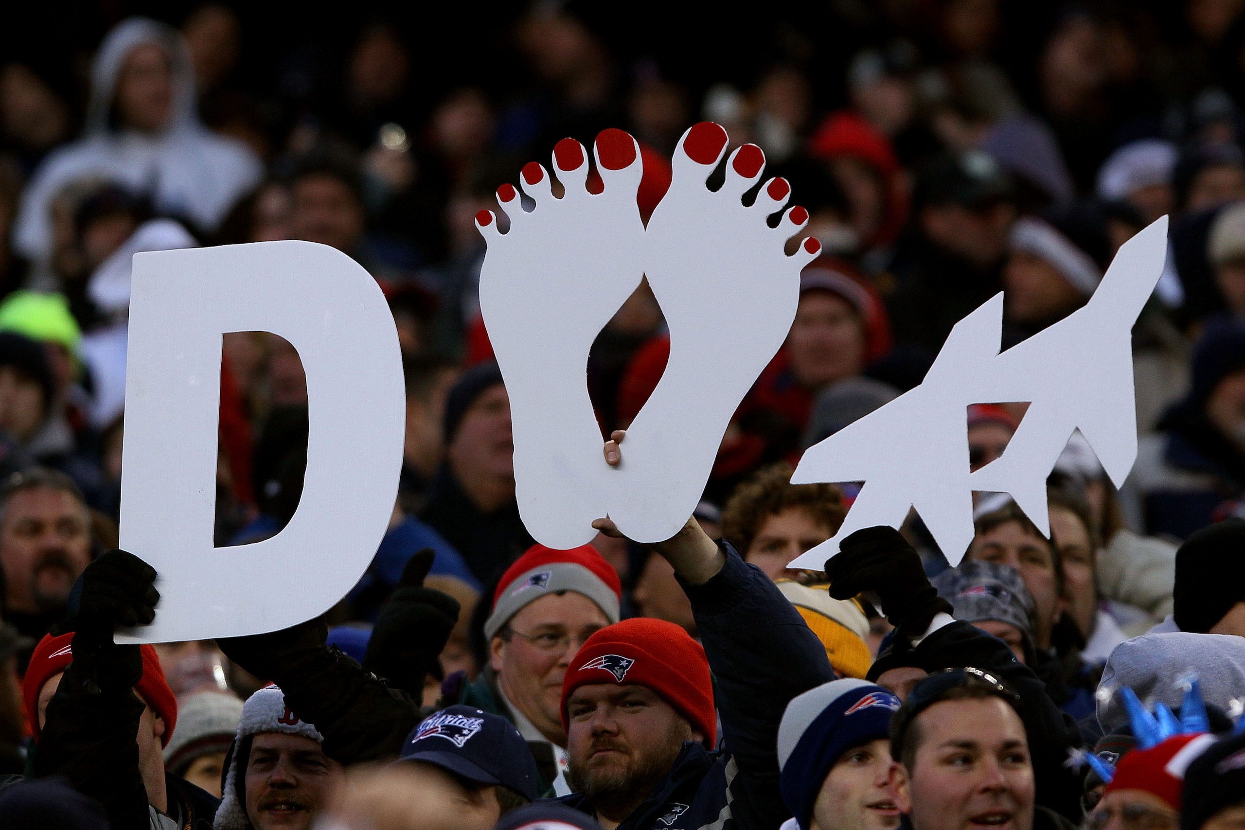 FOXBORO, MA - JANUARY 16:  New England Patriots fans hold up a signs prior to their 2011 AFC divisional playoff game against the New York Jets at Gillette Stadium on January 16, 2011 in Foxboro, Massachusetts.  (Photo by Elsa/Getty Images)