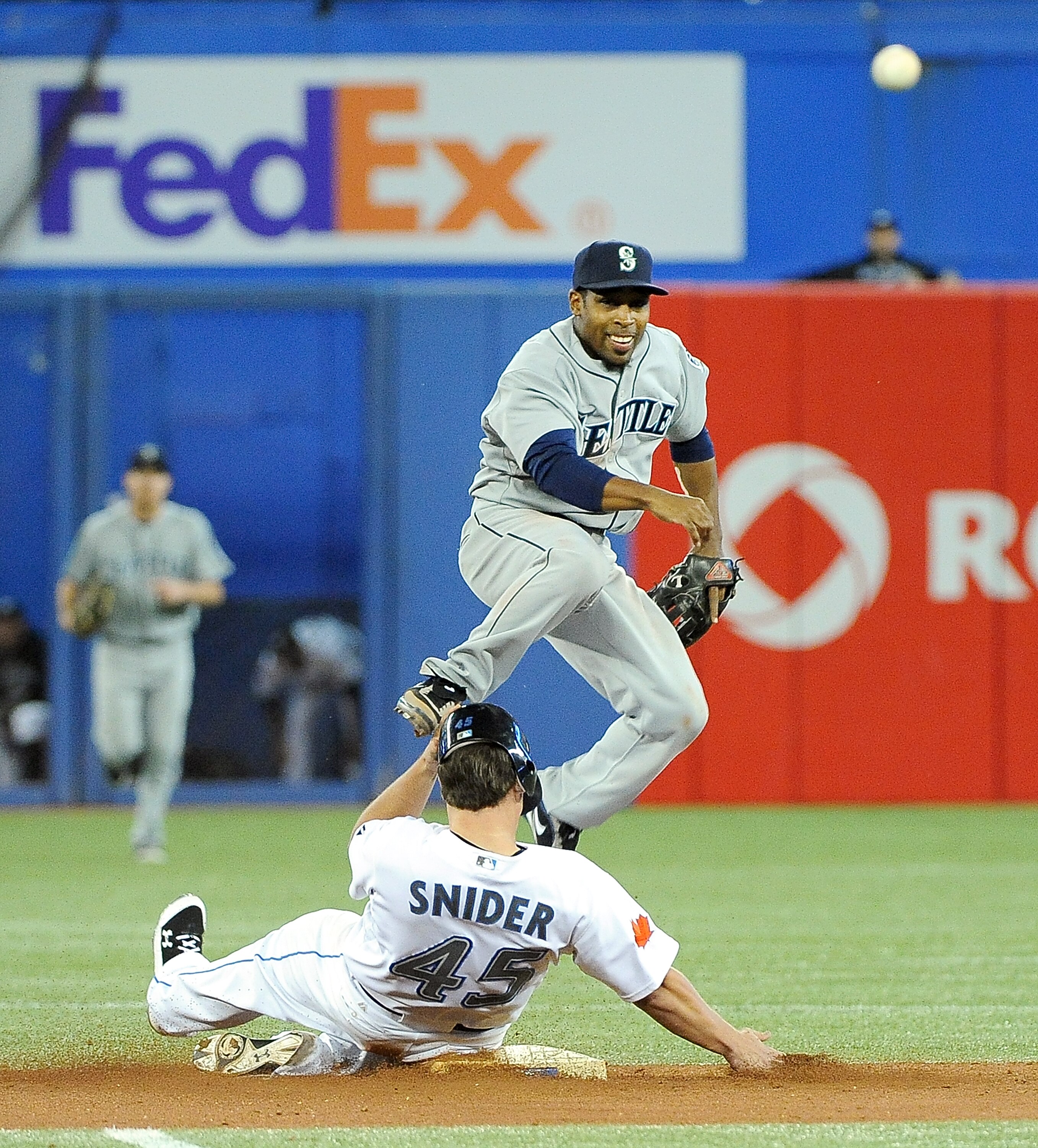 TORONTO, ON - SEPTEMBER 22: Chone Figgins #9 of the Seattle Mariners throws the ball to first base for a double play while Travis Snider #45 of the Toronto Blue Jays slides into second base on September 22, 2010 at the Rogers Centre in Toronto, Canada.  (