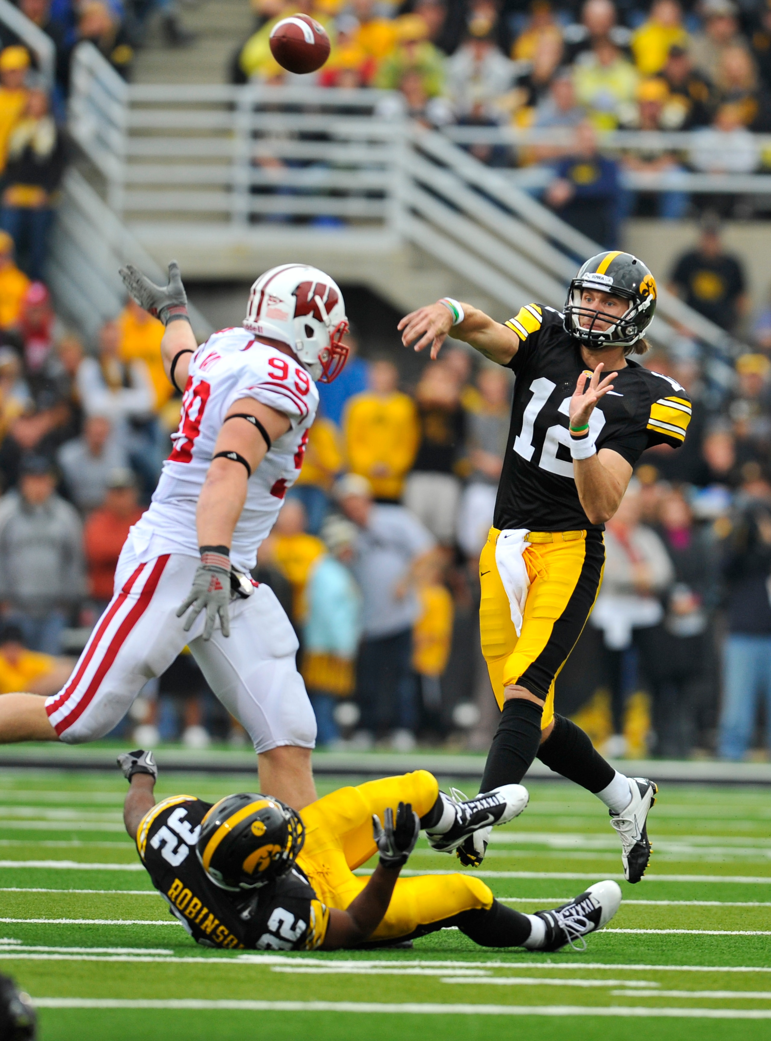 IOWA CITY, IA - OCTOBER 23: Quarterback Ricky Stanzi #12 of the University of Iowa Hawkeyes throws under pressure from defensive lineman J.J. Watt #99 of the Wisconsin Badgers during the second half of play at Kinnick Stadium on October 23, 2010 in Iowa C