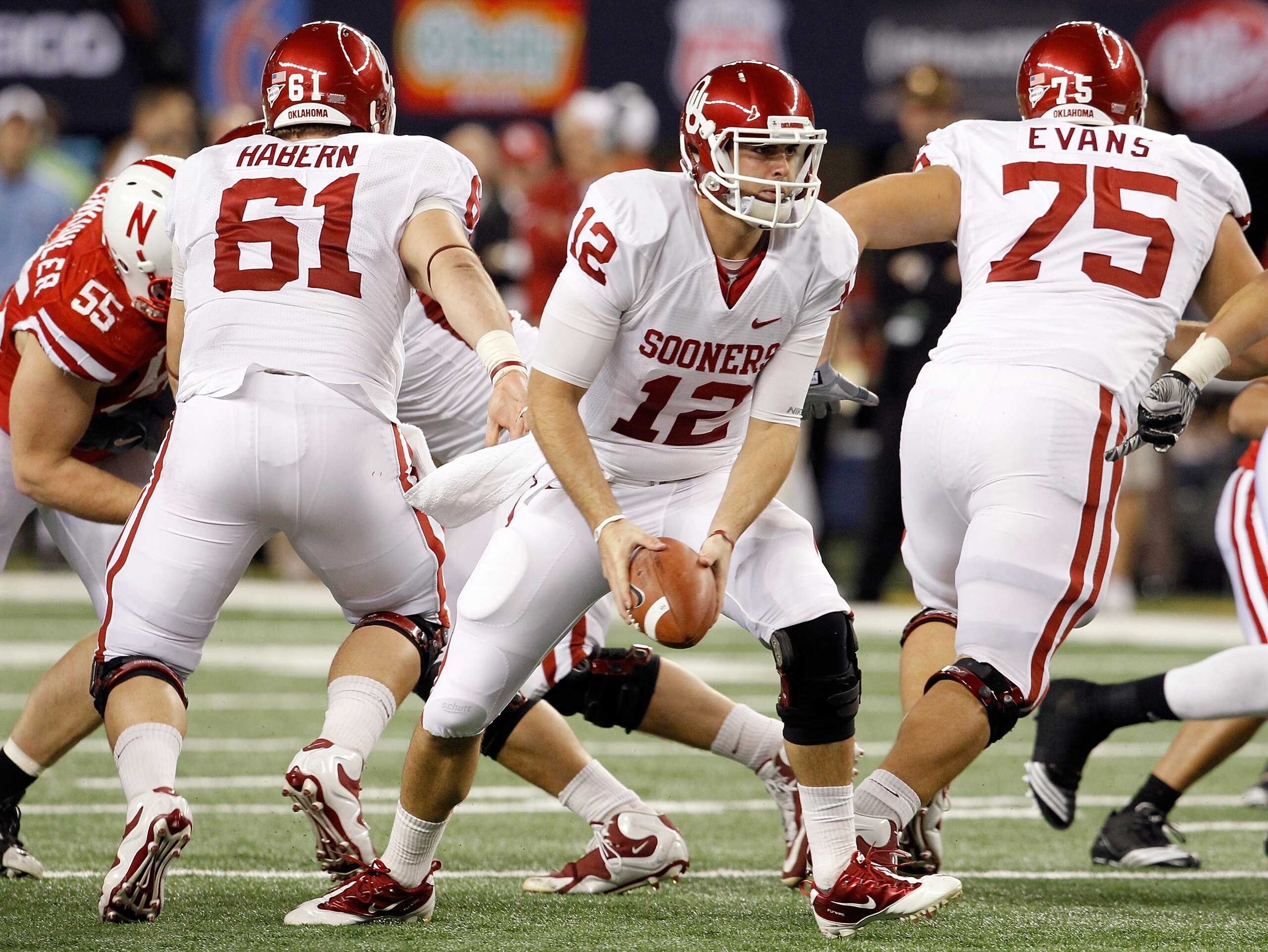 ARLINGTON, TX - DECEMBER 04:  Quarterback Landry Jones #12 of the Oklahoma Sooners looks for an open receiver against the Nebraska Cornhuskers at Cowboys Stadium on December 4, 2010 in Arlington, Texas.  The Sooners beat the Cornhuskers 23-20.  (Photo by