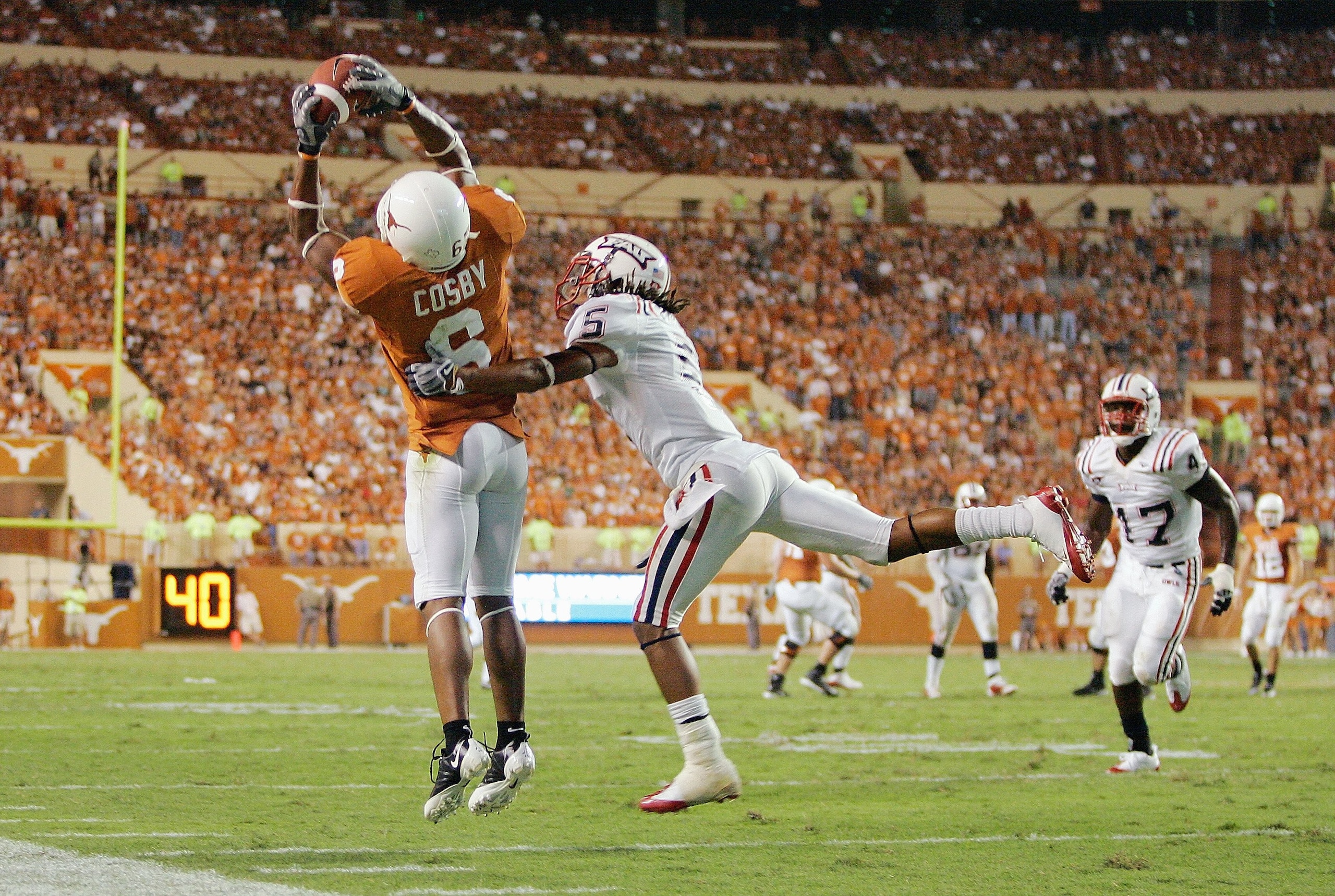 AUSTIN, TX - AUGUST 30:  Quan Cosby #6 of the Texas Longhorns leaps for the catch against Tavious Polo #5 of the Florida Atlantic Owls on August 30, 2007 at Darrell K Royal-Texas Memorial Stadium in Austin, Texas.  Texas won 52-10. (Photo by Brian Bahr/Ge