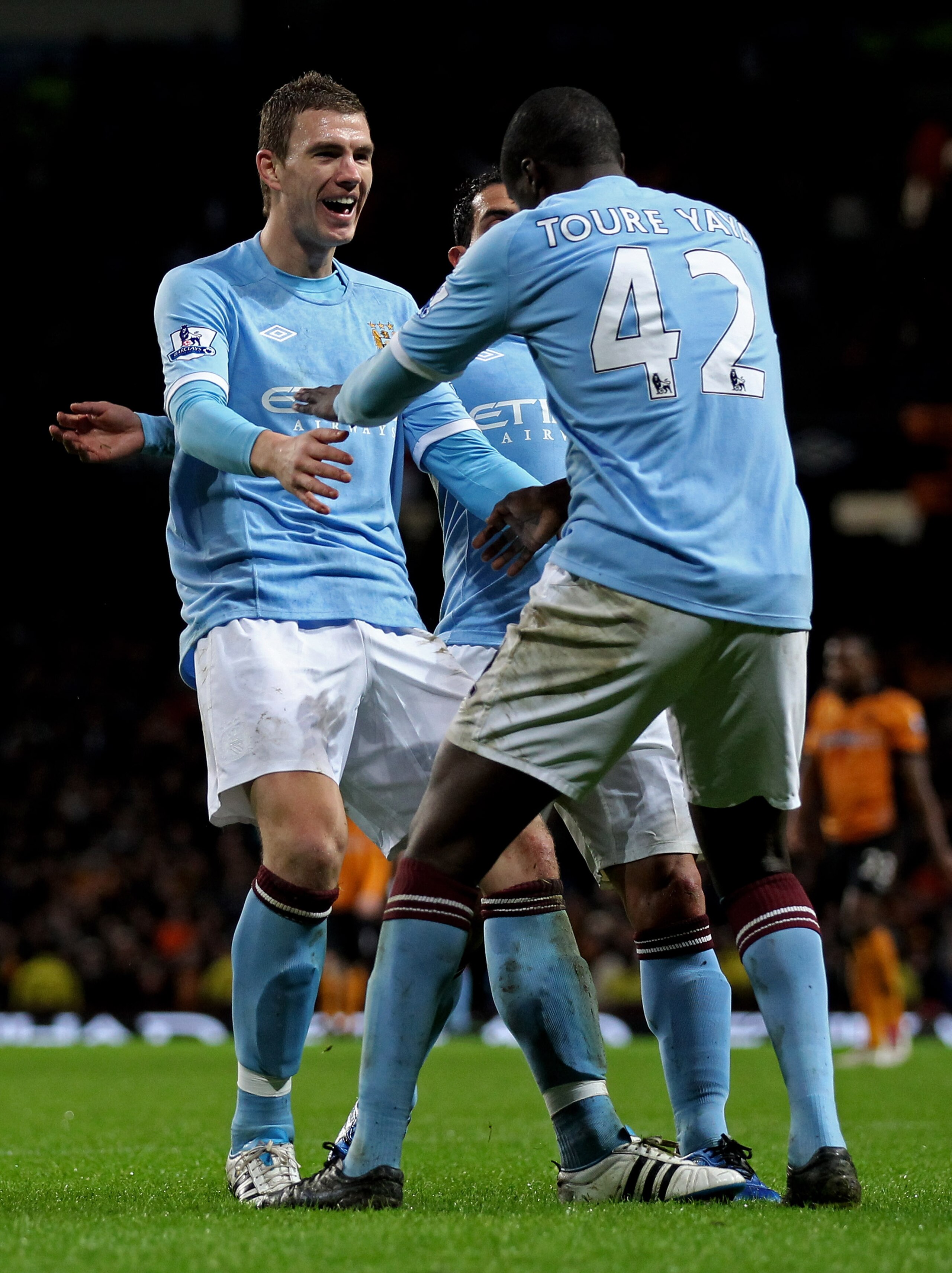 MANCHESTER, ENGLAND - JANUARY 15:  Yaya Toure of Manchester City celebrates scoring his team's third goal with team mates Edin Dzeko  (L) and Carlos Tevez during the Barclays Premier League match between Manchester City and Wolverhampton Wanderers at the