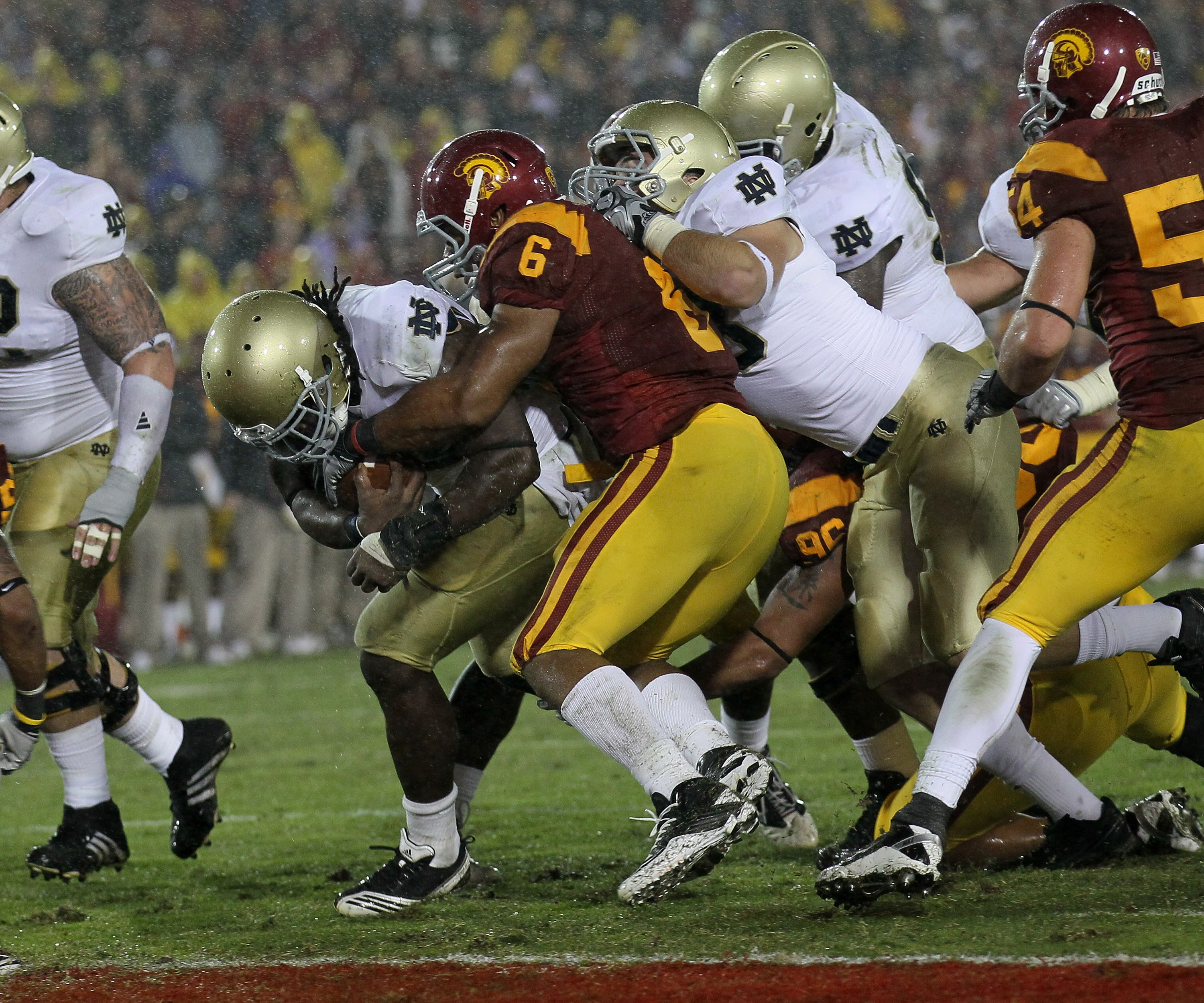 LOS ANGELES, CA - NOVEMBER 27:  Running back Robert Hughes #33 of the Notre Dame Fighting Irish carries on a five yard run to score the eventual winning touchdown in the fourth quarter through the tackle of linebacker Malcolm Smith #6 of the USC Trojans a