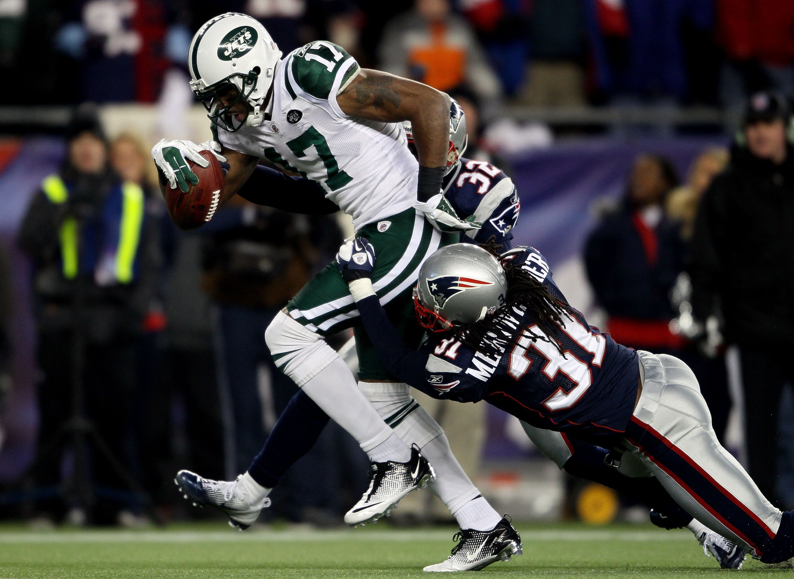 FOXBORO, MA - JANUARY 16:  Braylon Edwards #17 of the New York Jets scores a second quarter touchdown as Devin McCourty #32 and Brandon Meriweather #31 of the New England Patriots attempt to tackle during their 2011 AFC divisional playoff game at Gillette