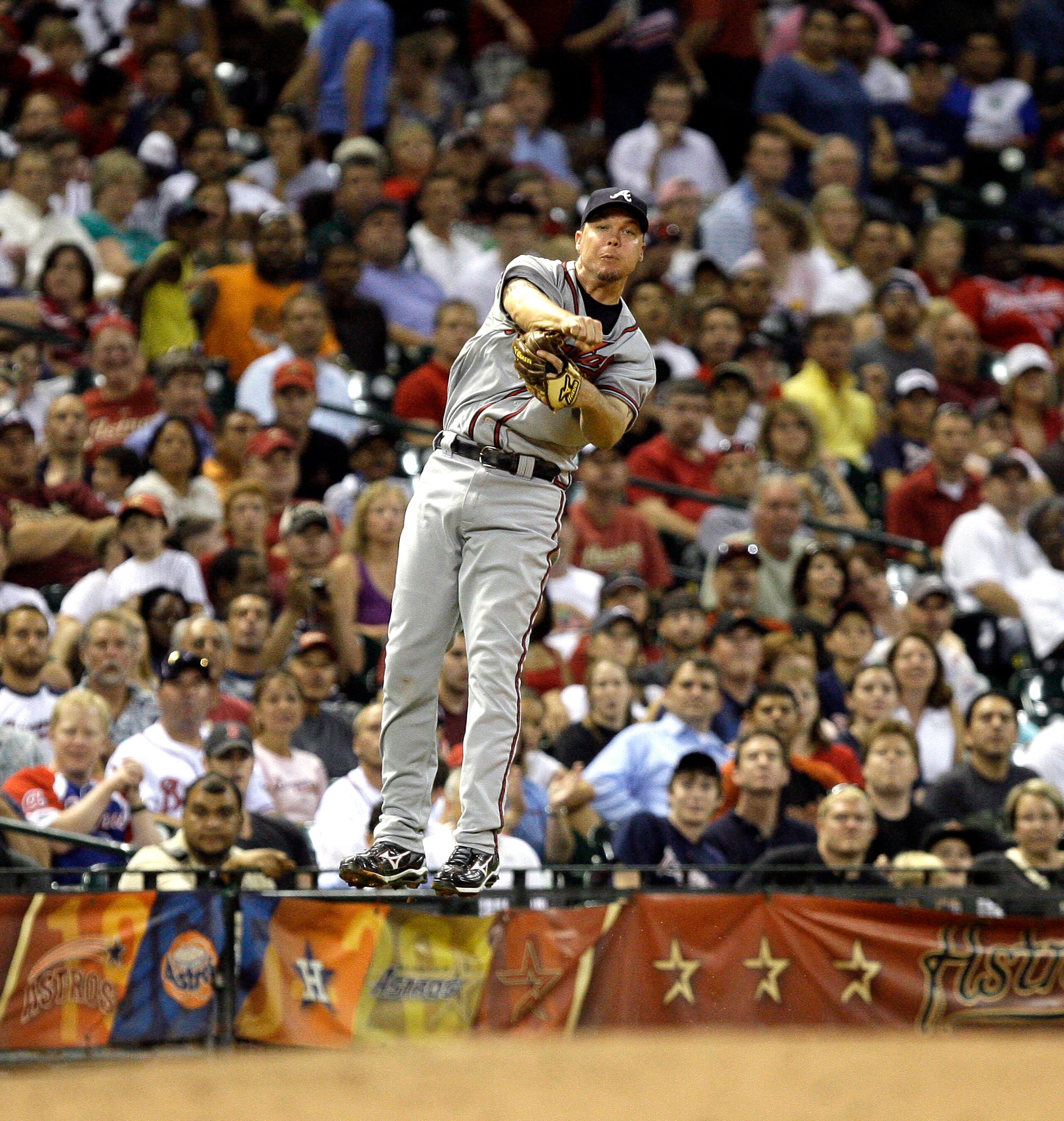 HOUSTON - AUGUST 10:  Third baseman Chipper Jones #10 of the Atlanta Braves throws out Hunter Pence of the Houston Astros from deep behind the base at Minute Maid Park on August 10, 2010 in Houston, Texas. Jones left the game after injuring himself on the