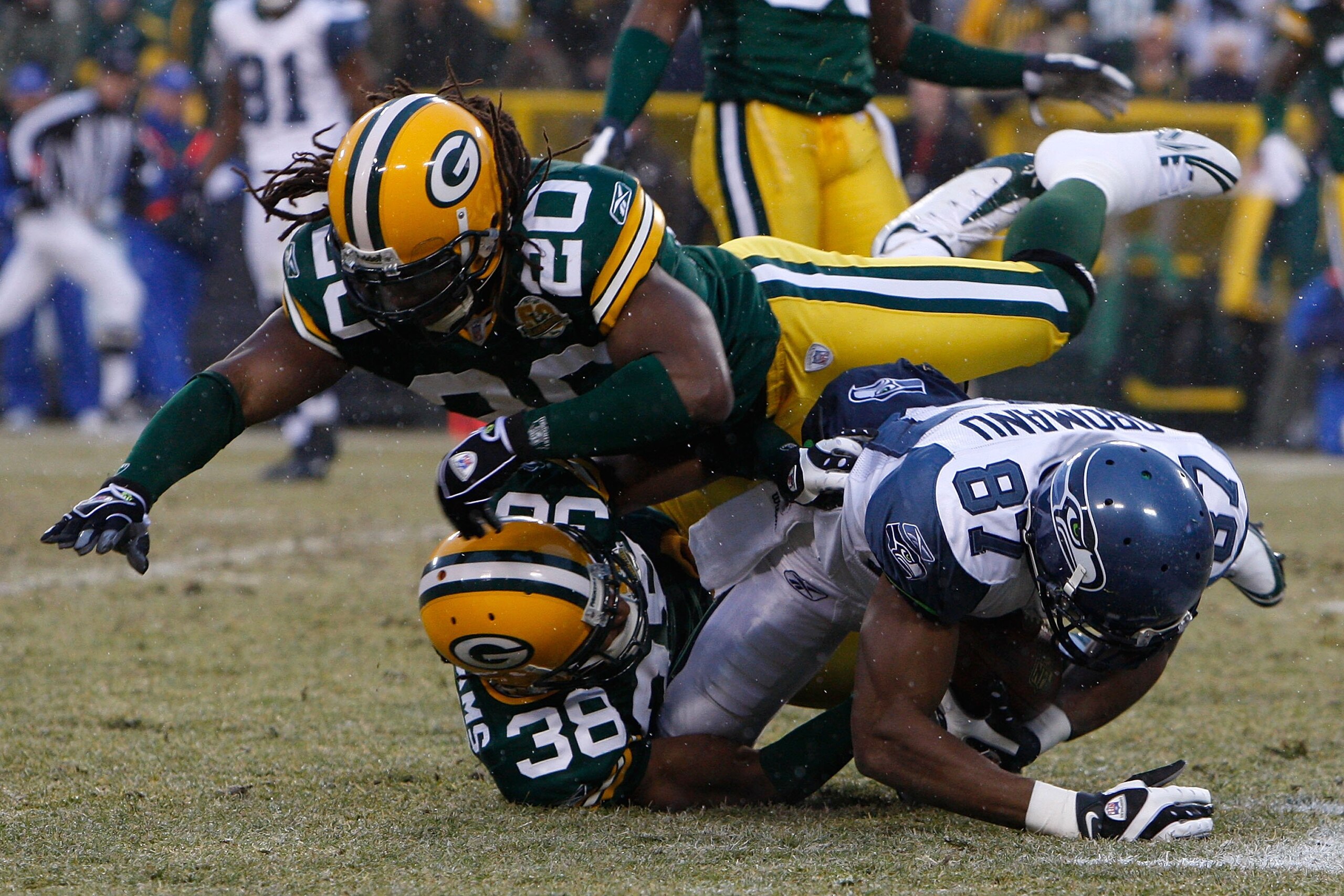GREEN BAY, WI - JANUARY 12:  Wide receiver Ben Obomanu #87 of the Seattle Seahawks is tackled by cornerback Tramon Williams #38 and safety Atari Bigby #20 of the Green Bay Packers during the NFC divisional playoff game on January 12, 2008 at Lambeau Field