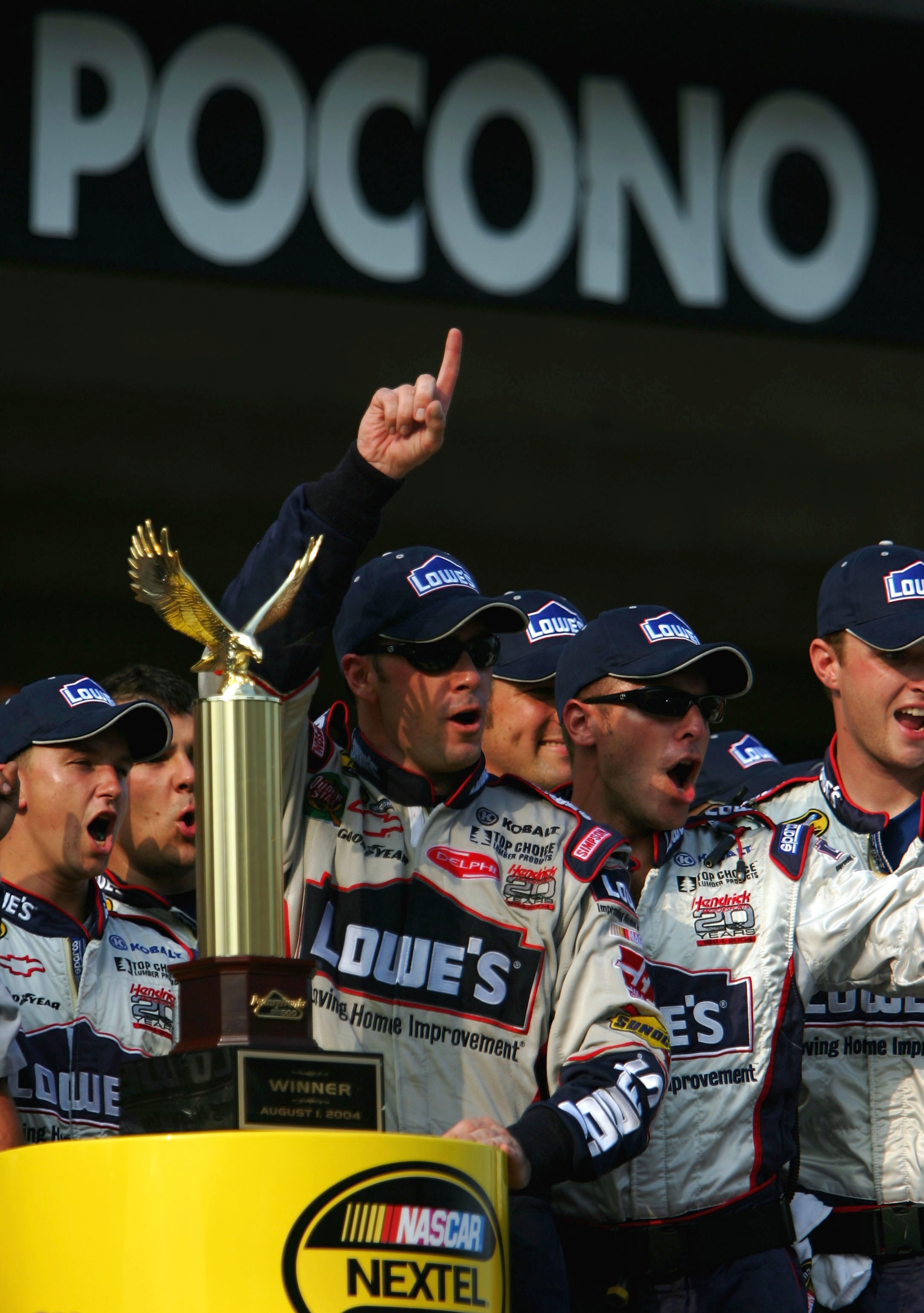 LONG POND, PA - AUGUST 1:  Jimmie Johnson driver of the #48 Lowe's Chevrolet  celebrates with the trophy and his crew in victory lane during the NASCAR Nextel Cup Pennsylvania 500 on August 1, 2004 at Pocono Raceway in Long Pond, Pennsylvania. (Photo by J