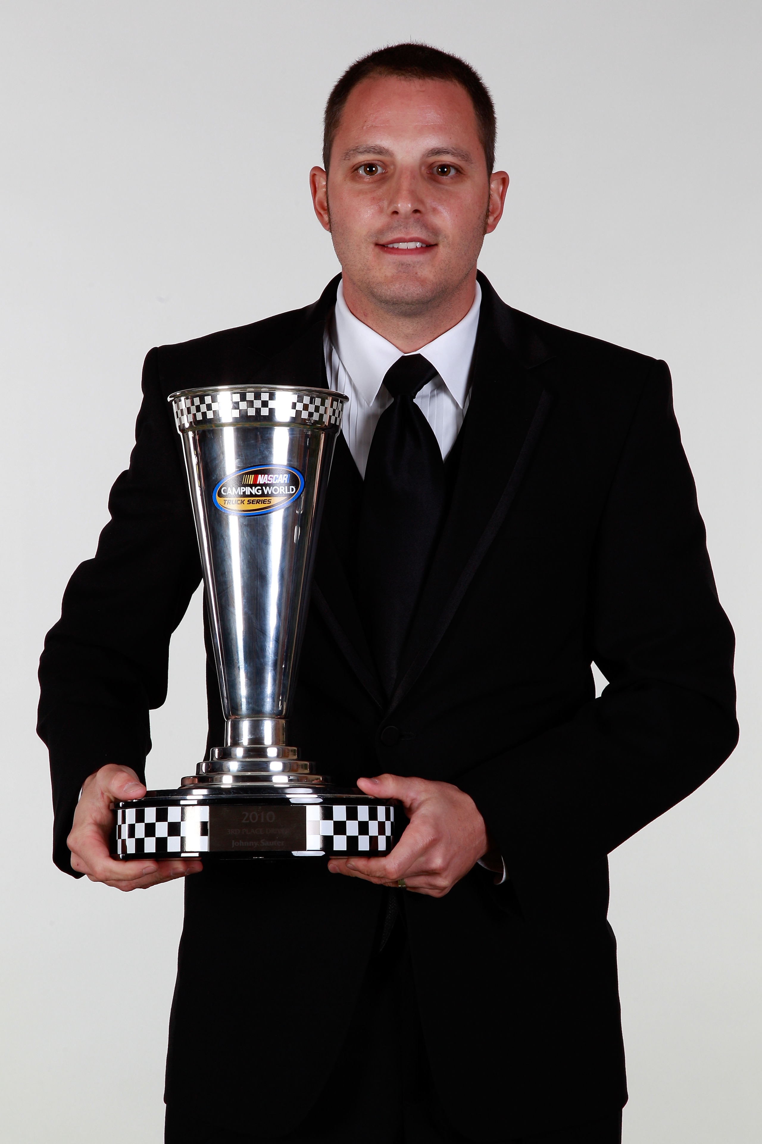 MIAMI - NOVEMBER 22:  Johnny Sauter, driver of the #13 FarmPaint.com/Curb Records Chevrolet, poses with the 3rd place Camping World Truck Series trophy during the NASCAR Nationwide/Camping World Truck Series Banquet at Loews Miami Beach Hotel on November