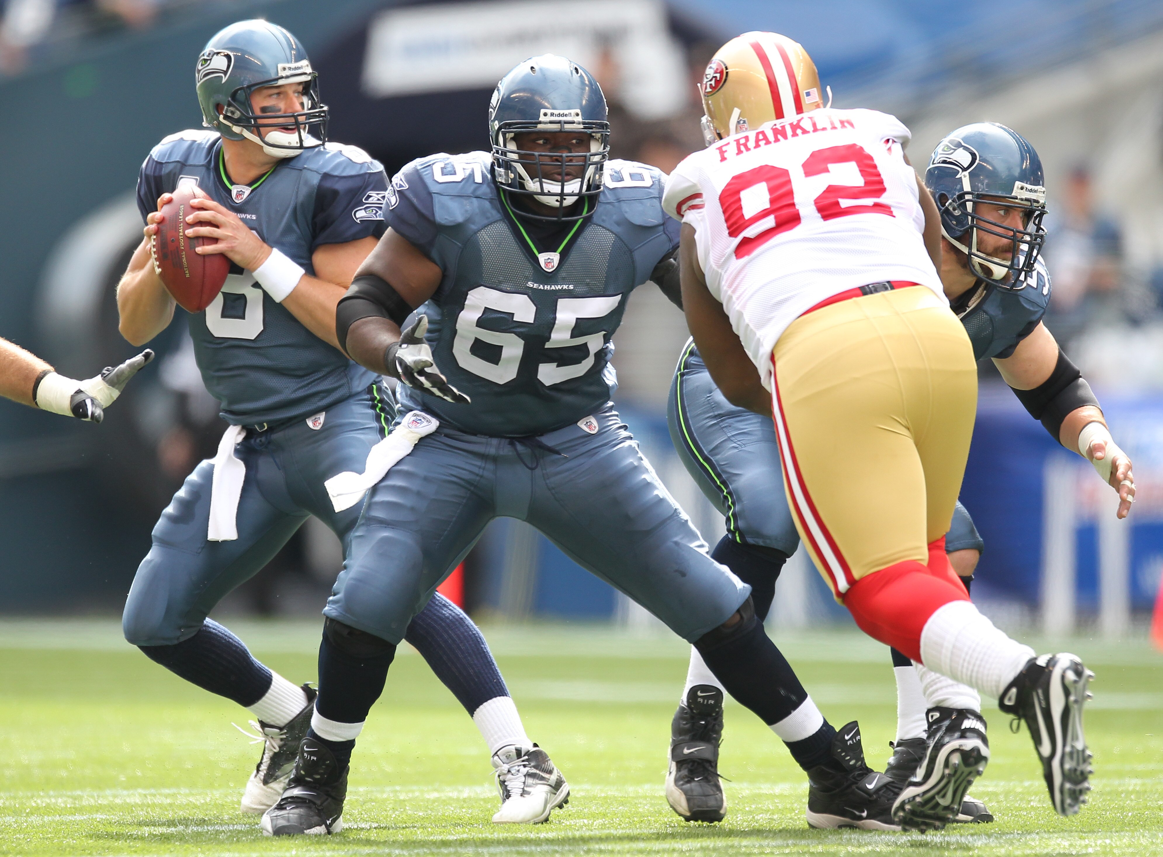 SEATTLE - SEPTEMBER 12:  Quarterback Matt Hasselbeck #8 of the Seattle Seahawks drops back to pass as Chris Spencer #65 and Ben Hamilton #50 defend against Aubrayo Franklin #92 of the San Francisco 49ers during the NFL season opener against at Qwest Field